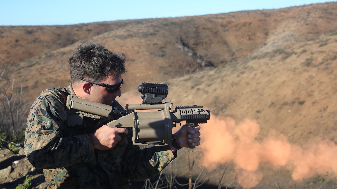 Lance Cpl. Kyle Gardner, a reconnaissance Marine with Force Company, 1st Reconnaissance Battalion, 1st Marine Division, fires the M32 Multiple Grenade Launcher during a physical training exercise aboard Marine Corps Base Camp Pendleton, Calif., Nov. 7, 2014. The M32 shoot was one of five events that took place during the exercise.