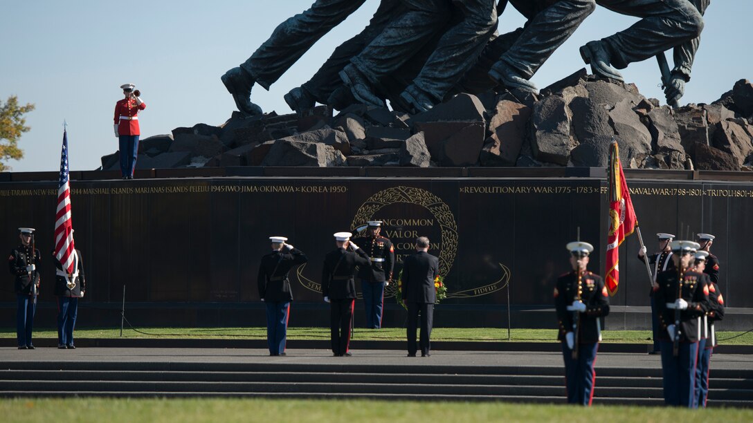 Maj. Paul Steketee, adjutant at the Marine Barracks, and Lance Cpl. Anthony Hill, body bearer with the ceremonial platoon at the Marine Barracks, salute as Sgt. Jason Pena, bugler with The United States Drum and Bugle Corps, plays taps at the grave site of Gen. Thomas Holcomb the 17th commandant of the Marine Corps in Arlington National Cemetery, Arlington, Virginia, November 10, 2014. Holcomb served as the commandant of the Marine Corps from 1936 to 1943.