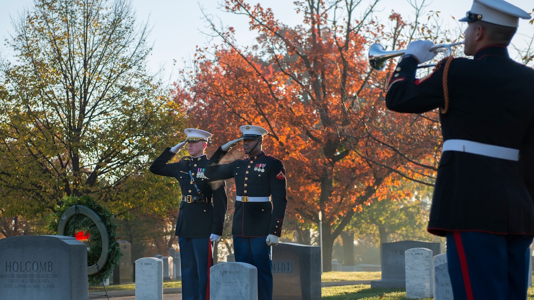 Maj. Paul Steketee, adjutant at the Marine Barracks, and Lance Cpl. Anthony Hill, body bearer with the ceremonial platoon at the Marine Barracks, salute as Sgt. Jason Pena, bugler with The United States Drum and Bugle Corps, plays taps at the grave site of Gen. Thomas Holcomb the 17th commandant of the Marine Corps in Arlington National Cemetery, Arlington, Virginia, November 10, 2014. Holcomb served as the commandant of the Marine Corps from 1936 to 1943.