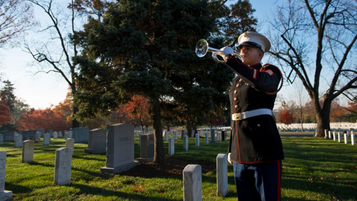 Sgt. Jason Pena, a bugler with The Marine Corps Drum and Bugle Corps, plays taps after a wreath was placed at the grave site of Gen. Thomas Holcomb, the 17th commandant of the Marine Corps, in Arlington National Cemetery, Arlington, Virginia, November 10, 2014. Holcomb served as the commandant of the Marine Corps from 1936 to 1943.