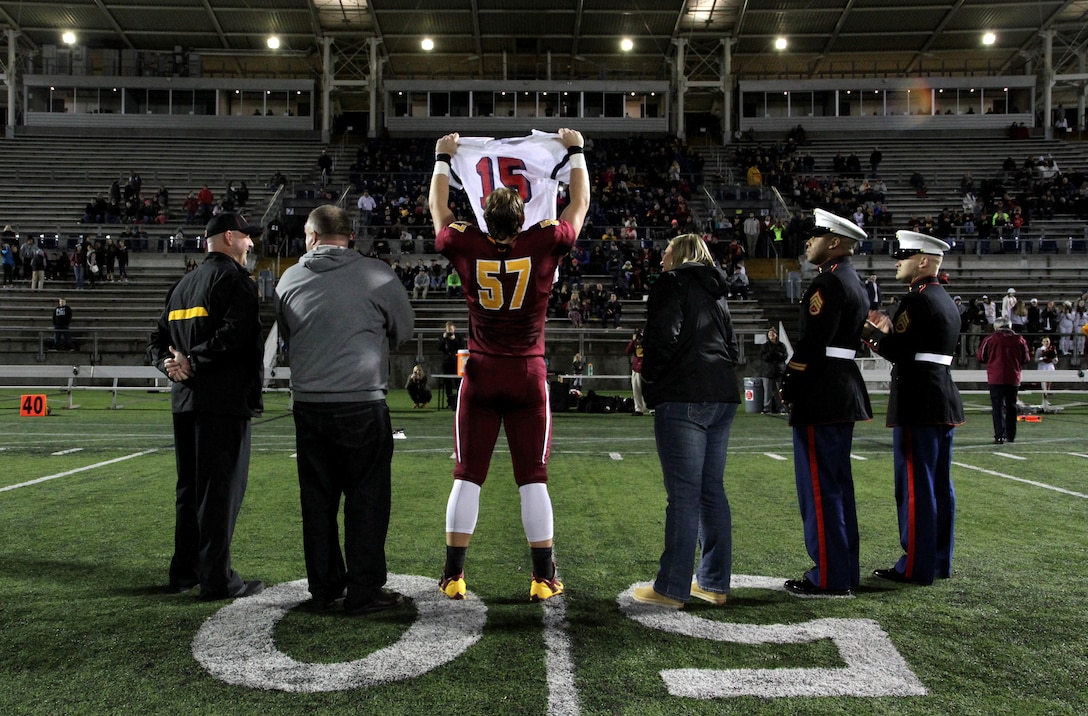 Blake Brandel, offensive lineman for the Central Catholic High School Rams, accepts his Semper Fidelis All American Bowl jersey with his parents Tanya and Scott Brandel along with head coach Steve Tyne during halftime of Central Catholic’s playoff game Nov. 7. Blake distinguished himself as a smart, well-rounded student athlete who maintains a grade point average of 3.5, and enjoys art and singing.
