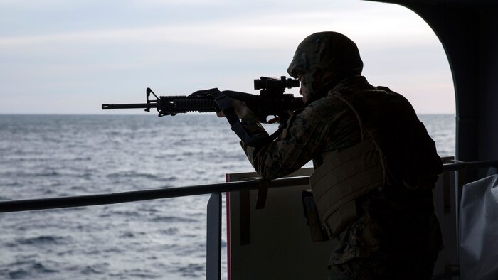 A Marine with Combat Logistics Regiment 25, 2nd Marine Logistics Group, guards his post during a full-ship security drill aboard the cargo and ammunition ship USNS Medgar Evers, Nov. 4, 2014. The Marines worked in concert with civilians aboard the ship to test expeditionary resupply capabilities during exercise Bold Alligator 14, a training operation designed to test the Navy-Marine Corps team’s ability to conduct crisis response operations. 