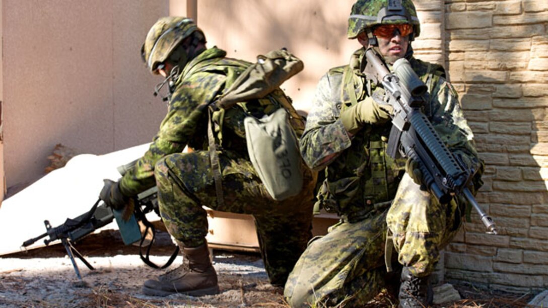 Two Canadian soldiers provide security for coalition forces during an assault on a combat town in Marine Corps Base Camp Lejeune, North Carolina on Nov. 7, 2014. This was one of the many training events of Bold Alligator 2014. A large-scale amphibious exercise on the East Coast designed to improve U.S. and allied forces response to a myriad of different crises. Allies from Canada, the United Kingdom, the Netherlands, Spain and Italy participated in the assault.