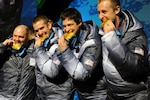 Former Utah National Guard bobsledder Steven Holcomb and teammates Justin Olsen, Steve Mesler and Curt Tomasevicz bite their gold medals at Whistler Medals Plaza after winning the Olympic four-man bobsled crown at Whistler Sliding Centre Feb. 27, 2010.