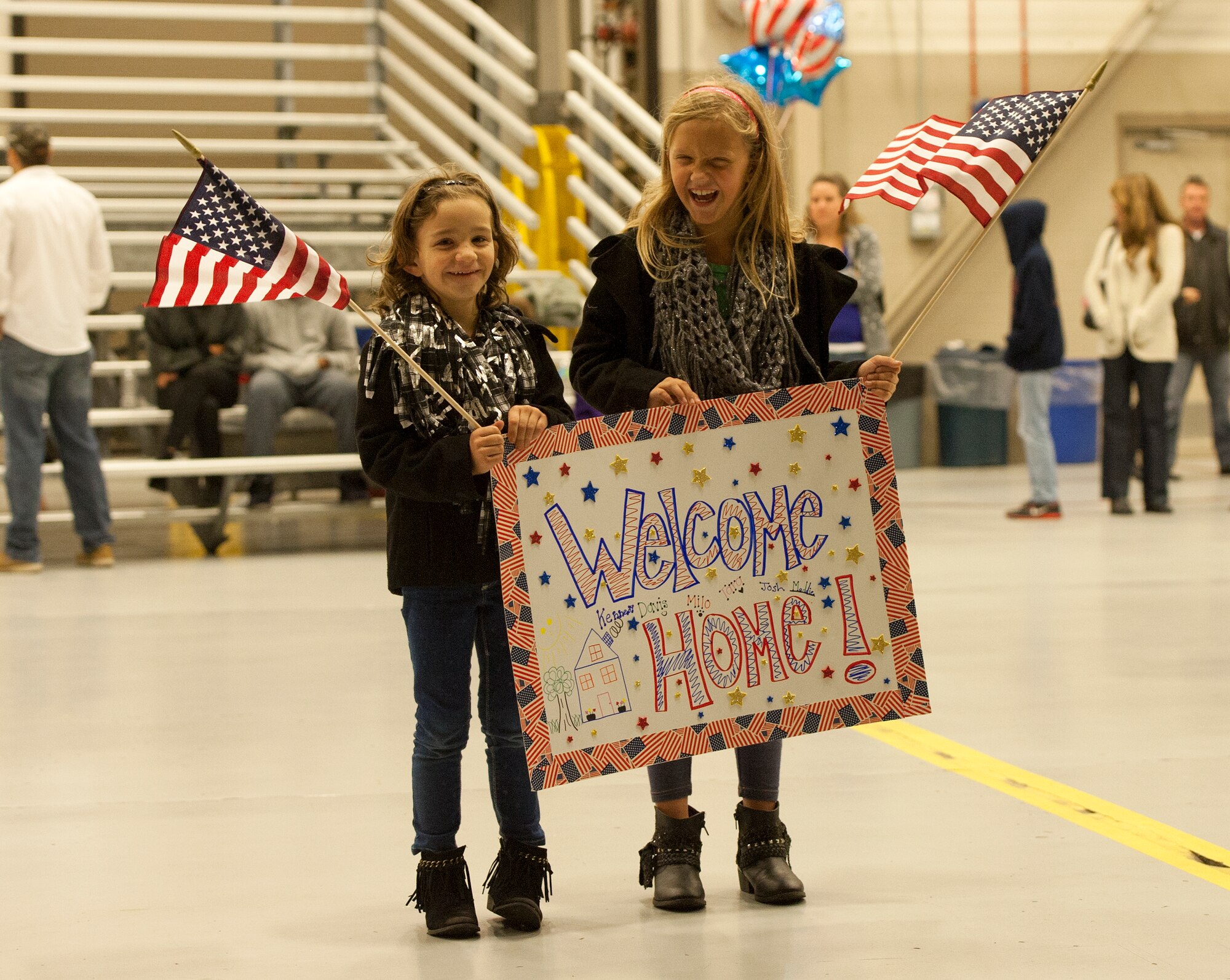 Kennedy Romin, age six, and Madelyn Romin, age eight, wait for their father to return from his deployment during Operation Homecoming at Hurlburt Field, Fla., Nov. 7, 2014. Family and friends were among the first to greet returning Air Commandos. (U.S. Air Force photo/Senior Airman Kentavist P. Brackin)