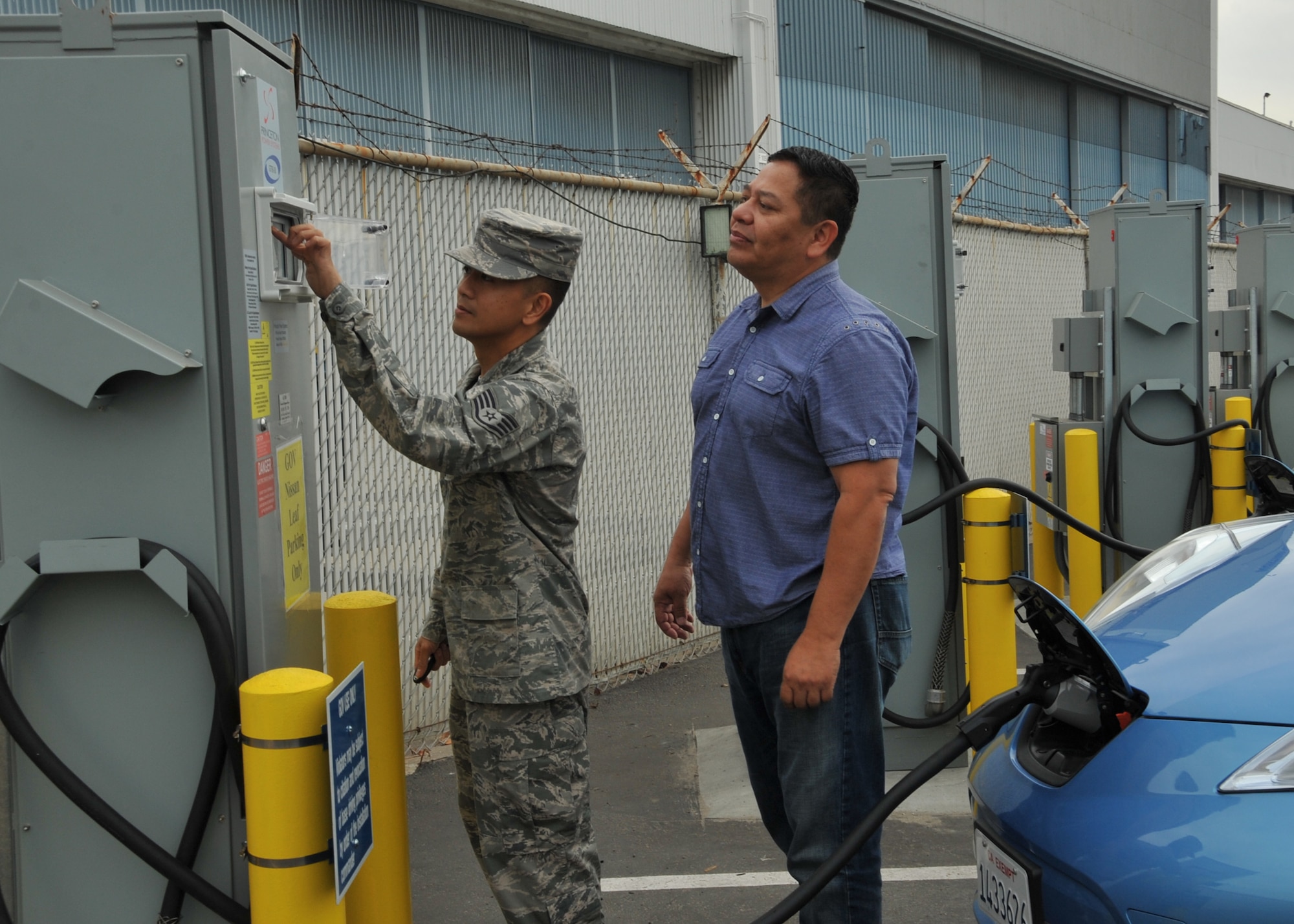 Staff Sgt Rey Sedantes (left), receives instruction on how to operate the Princeton bidirectional electric vehicle charging stations from vehicle operations contractor, Oscar Machado, right, during a training demo Oct. 31, 2014, in El Segundo, Calif. The charging stations will charge the electric vehicles directly from the local utility grid enabling Los Angeles Air Force Base personnel to utilize the electric vehicles as transportation within the base. When called-upon, and when connected to the electric vehicle, the bidirectional charging station will switch power flow directions in order to support vehicle-to-grid energy request by discharging the electric vehicle’s onboard battery. Sedantes is with the 61st Civil Engineering and Logistics Squadron. (U.S. Air Force photo/Sarah Corrice)