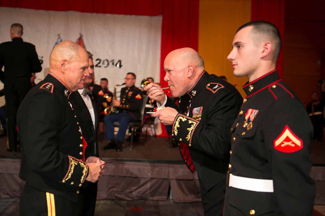 58-year-old Col. James P. Rethwisch, U.S. Marine Corps Forces Command (MARFORCOM) assistant chief of staff for G-1, takes a bite of a piece of birthday cake as the oldest Marine present for the ball after receiving it from Lt. Gen. Robert B. Neller, MARFORCOM commander, at the MARFORCOM 239th Marine Corps Birthday Ball on Nov. 8, 2014, at the Virginia Beach Convention Center. It is customary at Marine Corps birthday celebrations worldwide for Marines to cut a traditional cake in celebration of the birth of the Marine Corps on Nov. 10, 1775. The first piece of cake is given to the guest of honor, and the next piece is given to the oldest and youngest Marines present in the command to symbolize the passing of history and tradition to the next generation, as well as the experience and the youthful spirit that are hallmarks of the Marine Corps. The youngest Marine present was 19-year-old Pfc. James J. Gorman (left of Rethwisch), a brig guard with the Navy Consolidated Brig in Chesapeake, Va. Visit https://www.flickr.com/photos/marforcom/sets/72157648871588429/ for additional photos.