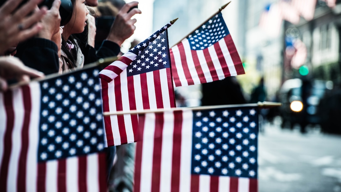 Spectators at New York City's Veterans Day Parade wave American flags from the sidewalks as they watch participants march by November 11, 2014. The event, also known as America's Parade, attracted more than 600,000 people and featured more than 20,000 participants including veterans of all eras, active duty personnel, ROTC and JROTC students, civic and youth groups, and organizations aimed at supporting and helping America’s veterans. 