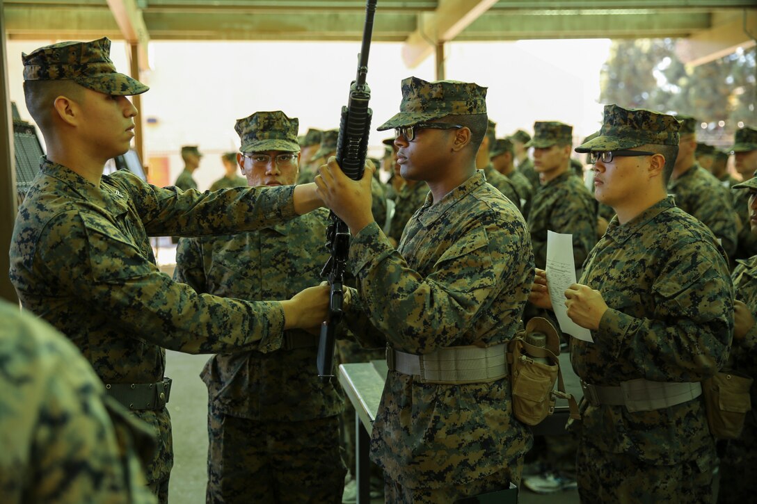 Cpl. Cesar Alvarado, armorer, Headquarters Company, Headquarters and Service Battalion, hands an M16-A4 Service Rifle to Recruit Koree D. Cartwright, Platoon 2127, Fox Company, 2nd Recruit Training Battalion, during the Rifle Issue event aboard Marine Corps Recruit Depot San Diego, Nov. 3.  Cartwright is a native of Houston and was recruited out of Recruiting Substation Memorial City, Texas.