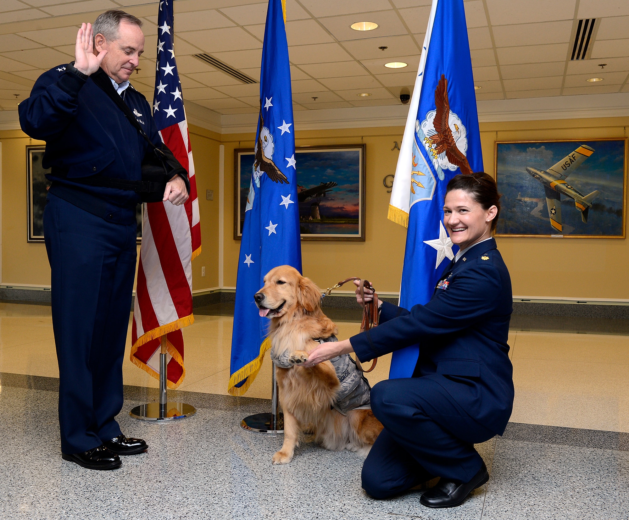 Second Lt. Goldie, a therapy dog from Walter Reed Bethesda Hospital, is administered the oath of office from Air Force Chief of Staff Gen. Mark A. Welsh III, with his handler, Maj. Regina Owens, a psychiatric nurse, during a promotion ceremony to the rank of major, Nov. 12, 2014, in the Pentagon. Goldie, along with a team of therapy dogs, provides comfort to the hospital's patients and family members.  (U.S. Air Force photo/Scott M. Ash)  