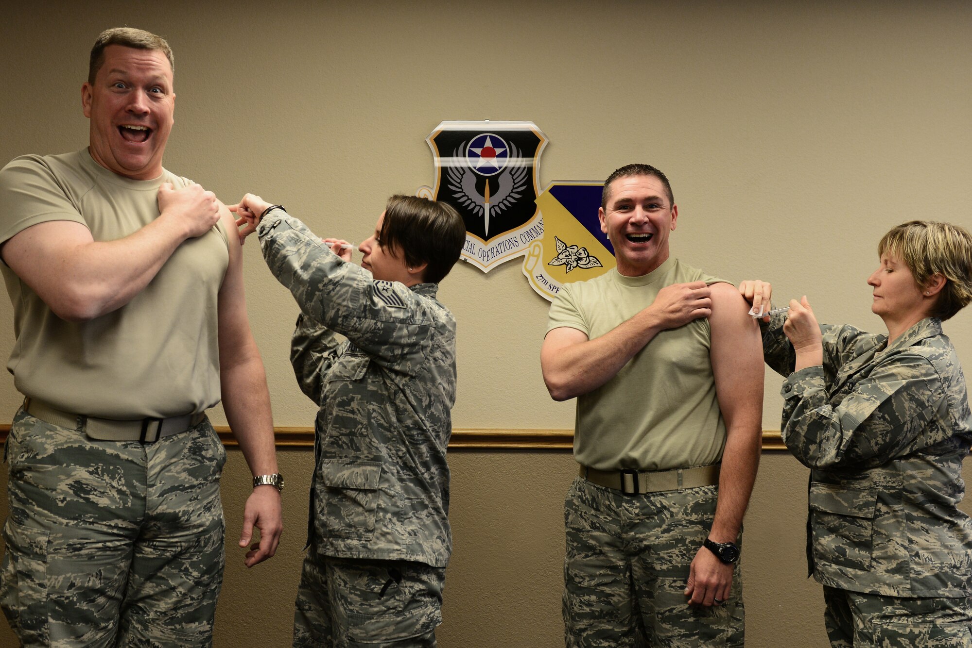 U.S. Air Force Col. Tony Bauernfeind, 27th Special Operations Wing commander, and Chief Master Sgt. Randy Scanlan, 27 SOW command chief, receive their annual flu vaccine from two medical personnel October 29, 2014 at Cannon Air Force Base, N.M. The Air Force has a goal of having 90 percent of military personnel vaccinated by mid-December, and Cannon is on track to surpass that goal by a month. (U.S. Air Force photo/Senior Airman Eboni Reece)
