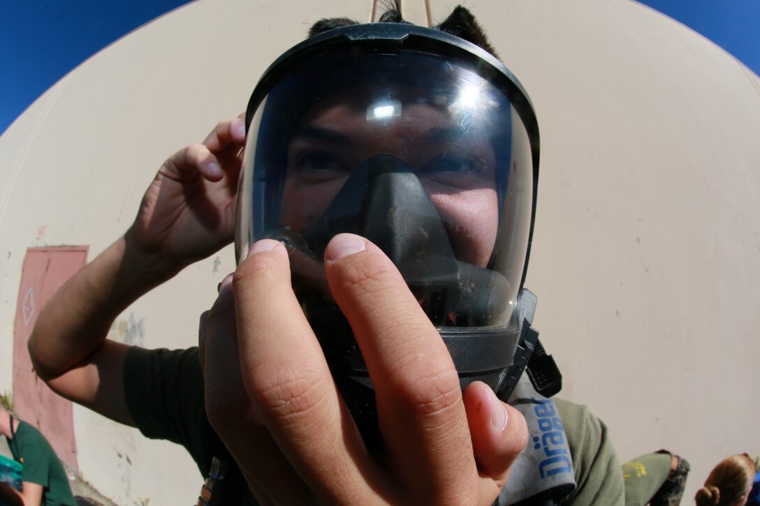 U.S. Marine Cpl. Richard A. Wilson adjusts his self-contained breathing apparatus during a hazardous material training scenario aboard Camp Pendleton, Calif., Nov. 5, 2014. Wilson is a chemical, biological, radiological and nuclear defense specialist with the 15th Marine Expeditionary Unit. (U.S. Marine Corps photo by Sgt. Jamean Berry/Released)