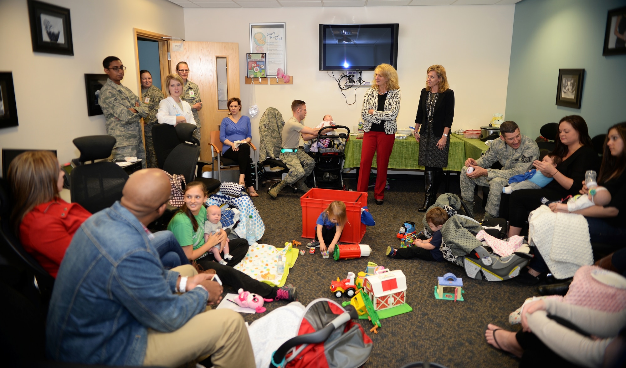 Cheryl Roberson, center, wife of Lt. Gen. Darryl Roberson, 3rd Air Force commander, and Dawn Novotny, wife of Col. Robert Novotny, 48th Fighter Wing commander, visit the “Village Friends” new parents support group at the 48th Medical Group at Royal Air Force Lakenheath, England, Nov. 13, 2014. The Robersons were visiting units around the wing during a base immersion tour. (U.S. Air Force photo by Staff Sgt. Emerson Nuñez/Released)