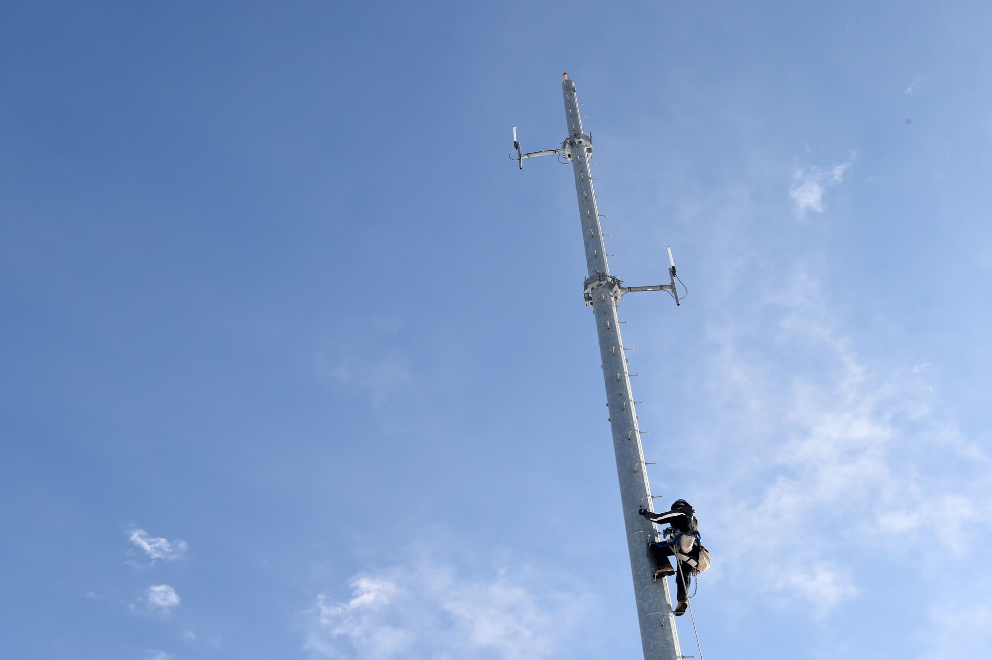 Adam Richter, United Tower Service tower technician, make his way up the radio communication tower during the installation of new equipment on Buckley Air Force Base, Colo. With the installation of the new system, Buckley will now be able to communicate by radio with Peterson AFB, Colorado; F.E. Warren AFB, Wyoming; Shriever AFB, Colorado; and Malmstrom AFB, Montana. (U.S. Air Force photo by Airman Emily E. Amyotte/Released)