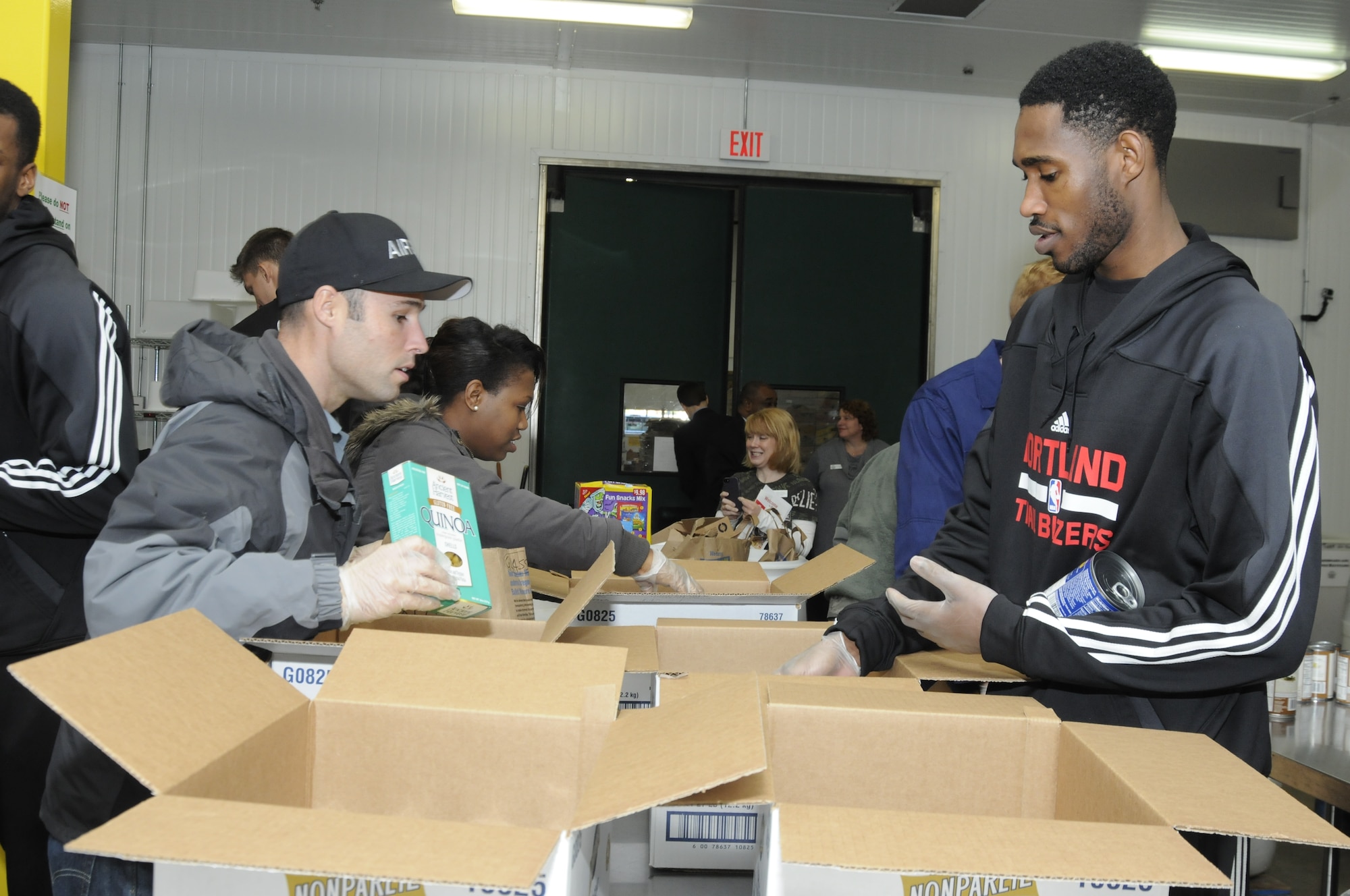 Tech. Sgt. Jacob Goodwin, a recruiter with Oregon National Guard Joint Force Headquarters who is stationed in Portland, works with Will Barton, a guard for the Portland Trail Blazers, as they pack food boxes to support the Oregon Food Bank. (U.S. Air National Guard photo by Capt. Angela Walz, 142nd Fighter Wing Public Affairs)