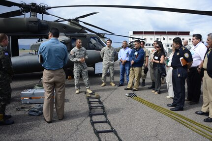 U.S. Army Sgt. Maynor Oliva, crew chief with the 1-228th Aviation Regiment, briefs Joint Task Force-Bravo’s Honduran Leaders’ Day guests on the capabilities of a UH-60L Black Hawk helicopter at Soto Cano Air Base, Honduras, Nov. 14, 2014.  Over 40 leaders from around the Republic of Honduras came to learn more about the mission and capabilities of JTF-Bravo and Soto Cano Air Base. (U.S. Air Force photo/Tech. Sgt. Heather Redman)