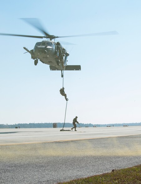 Special missions aviators from the 41st Rescue Squadron fast rope during a combat search and rescue demonstration at the 2014 Flying Tiger Reunion Heritage Day Nov. 14, 2014, on Moody Air Force Base, Ga. The multi-unit exhibition highlighted the capabilities of the 23d Wing’s HH-60G Pave Hawk, A-10C Thunderbolt II and HC-130J Combat King II. (U.S. Air Force photo by Airman 1st Class Ceaira Tinsley/Released)