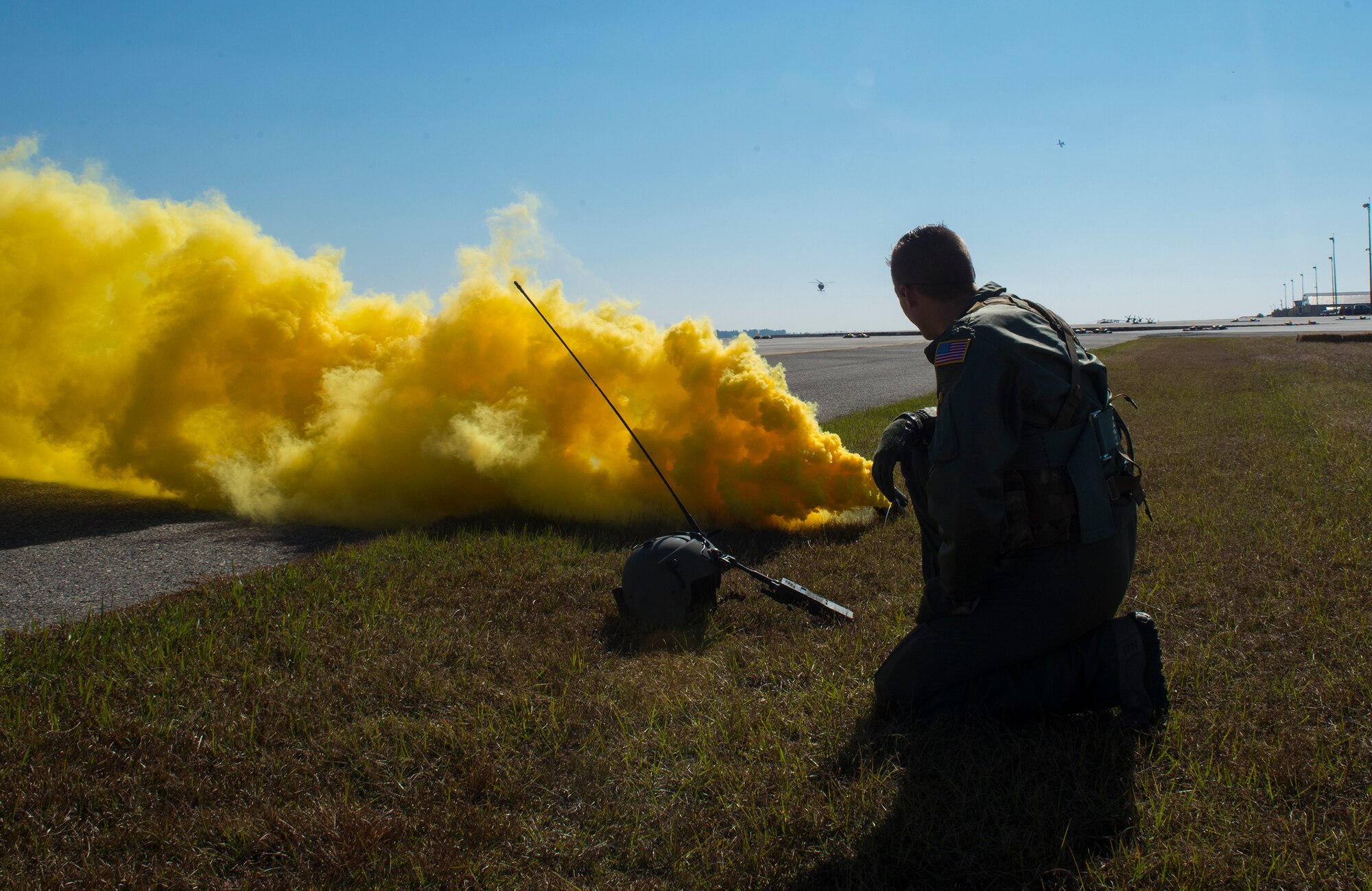 U.S. Air Force 1st Lt. Howard Palmer III, 41st Rescue Squadron HH-60G Pave Hawk pilot, looks at an approaching aircraft during the 2014 Flying Tiger Reunion Heritage Day combat search and rescue demonstration Nov. 14, 2014, at Moody Air Force Base, Ga. Palmer used the smoke as a distress signal to help pinpoint his location. (U.S. Air Force photo by Airman 1st Class Ceaira Tinsley/Released)