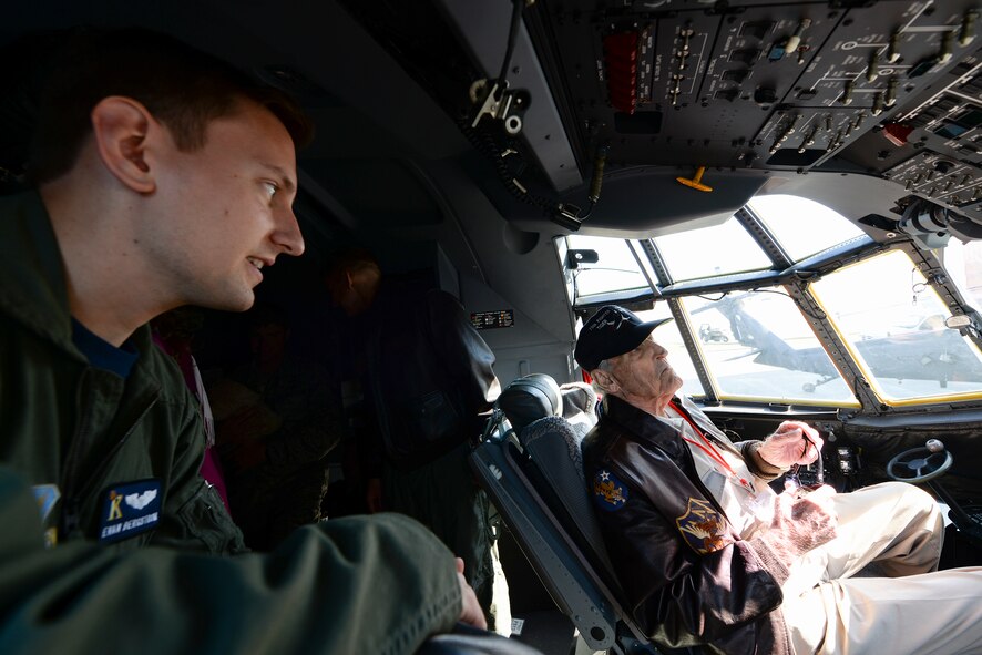 U.S. Air Force Capt. Evan Bergstrom, 71st Rescue Squadron HC-130J Combat King II pilot, talks about the upgraded controls in the aircraft with J.M. Taylor, a former 75th Fighter Squadron pilot and World War II veteran, during the 2014 Flying Tiger Reunion heritage day, Nov. 14, 2014, at Moody Air Force Base, Ga.  Taylor spent 10 months as a prisoner of war, including two months in solitary confinement.  (U.S. Air Force photo by Master Sgt. Sonny Cohrs/Released) 