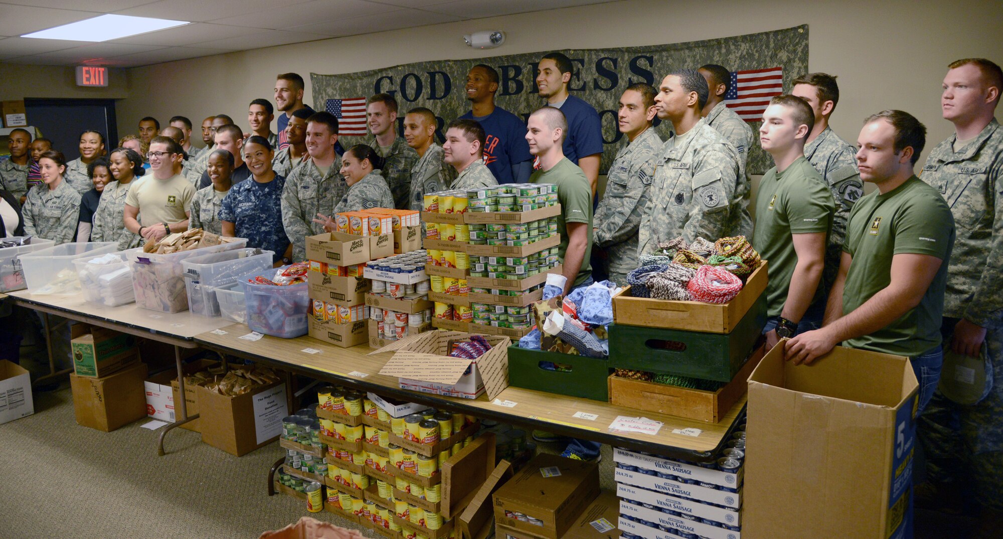 Airmen from Tinker, Vance and Altus Air Force Bases, a Sailor from Strategic Communications Wing One, members of the Oklahoma National Guard, Army recruiters and their future Soldiers, teamed up with members of the Oklahoma City Thunder to volunteer at The Hugs Project in northwest Oklahoma City last Saturday. The group assembled more than 400 care packages for deployed military members as part of the NBA’s Hoops for Troops initiative. (Air Force photo by Kelly White)