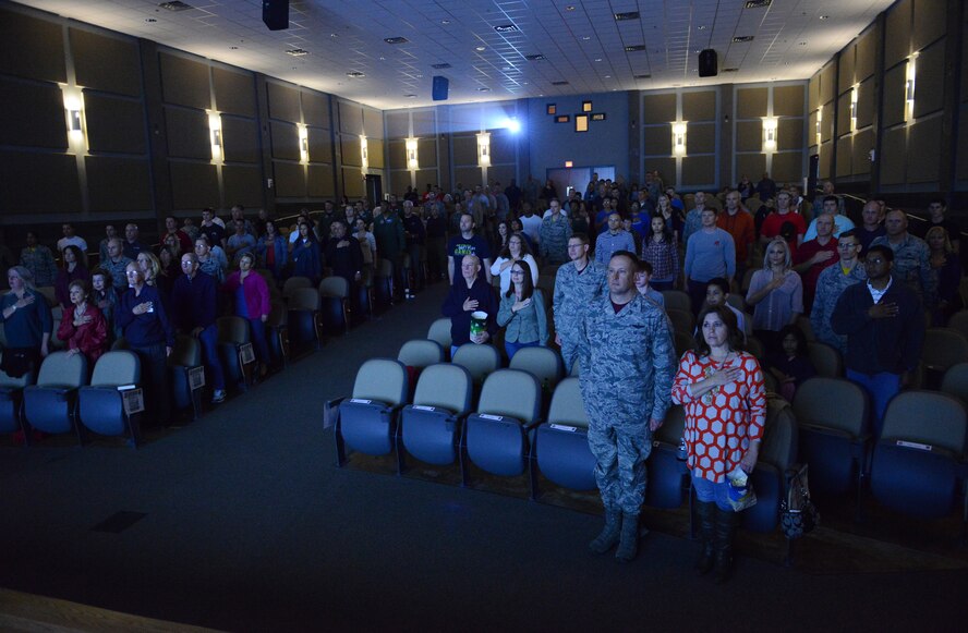 Team Dyess stands for the National Anthem before the showing of the movie “4-4-43” Nov. 7, 2014, at Dyess Air Force Base, Texas. The Dyess community came out to support the triumph and bravery of the man behind the base’s namesake. (U.S. Air Force photo by Airman 1st Class Kedesha Pennant/Released)