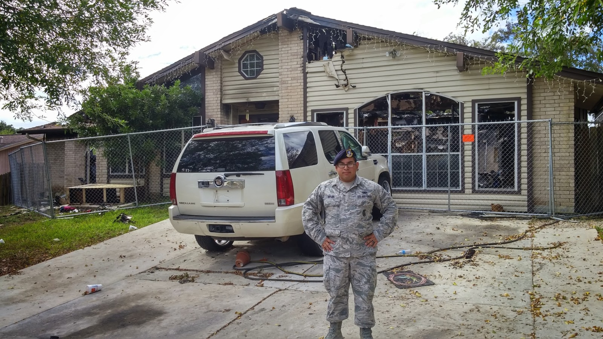 Senior Airman Christopher Taylor, 802nd Security Forces Squadron pass and processing, stands outside the remains of the burnt building in San Antonio. Taylor saved a disabled man from a fire, Nov. 3. The man was admitted to the San Antonio Military Medical Complex where he remains for treatment due to minor burns on the left side of his body and severe smoke inhalation. (U.S. Air Force photo by Senior Airman Lynsie Nichols/released).