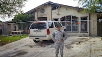 Senior Airman Christopher Taylor, 802nd Security Forces Squadron pass and processing, stands outside the remains of the burnt building in San Antonio. Taylor saved a disabled man from a fire, Nov. 3. The man was admitted to the San Antonio Military Medical Complex where he remains for treatment due to minor burns on the left side of his body and severe smoke inhalation. (U.S. Air Force photo by Senior Airman Lynsie Nichols/released).