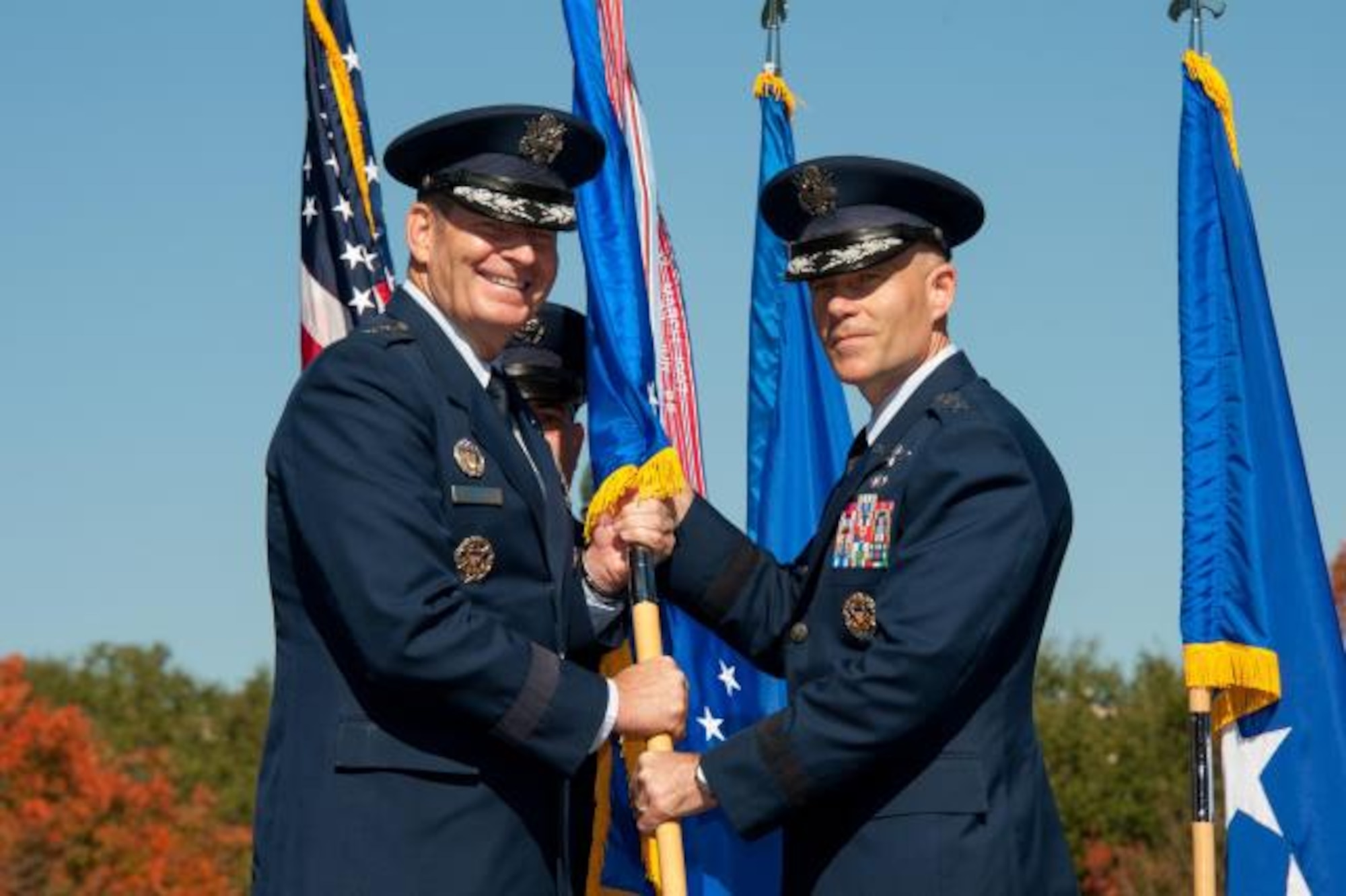 General Robin Rand, commander Air Education and Training Command, hands the Air University guidon to the university’s new commander and president, Lt. Gen. Steven Kwast, during a change of command ceremony, Nov. 10, 2014, at Maxwell Air Park. (Photo by Melanie Rodgers Cox)

