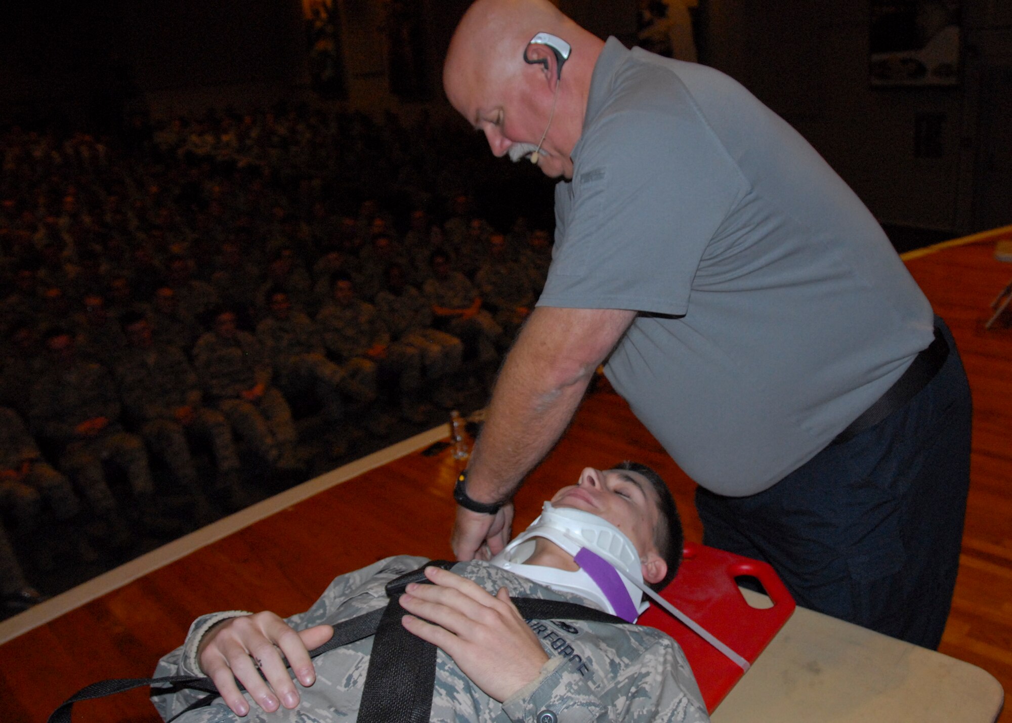 Airman 1st Class Andrew McWilliams, of the 33rd  Aircraft Maintenance Squadron, is placed on a spinal board for transportation to a hospital by Greg McCarty, a Florida Stay Alive From Education instructor, as part of a car accident victim demonstration during the “Street Smart” program at the Holiday Traffic Safety Campaign Nov. 13.  (U.S. Air Force photo/Kevin Gaddie)