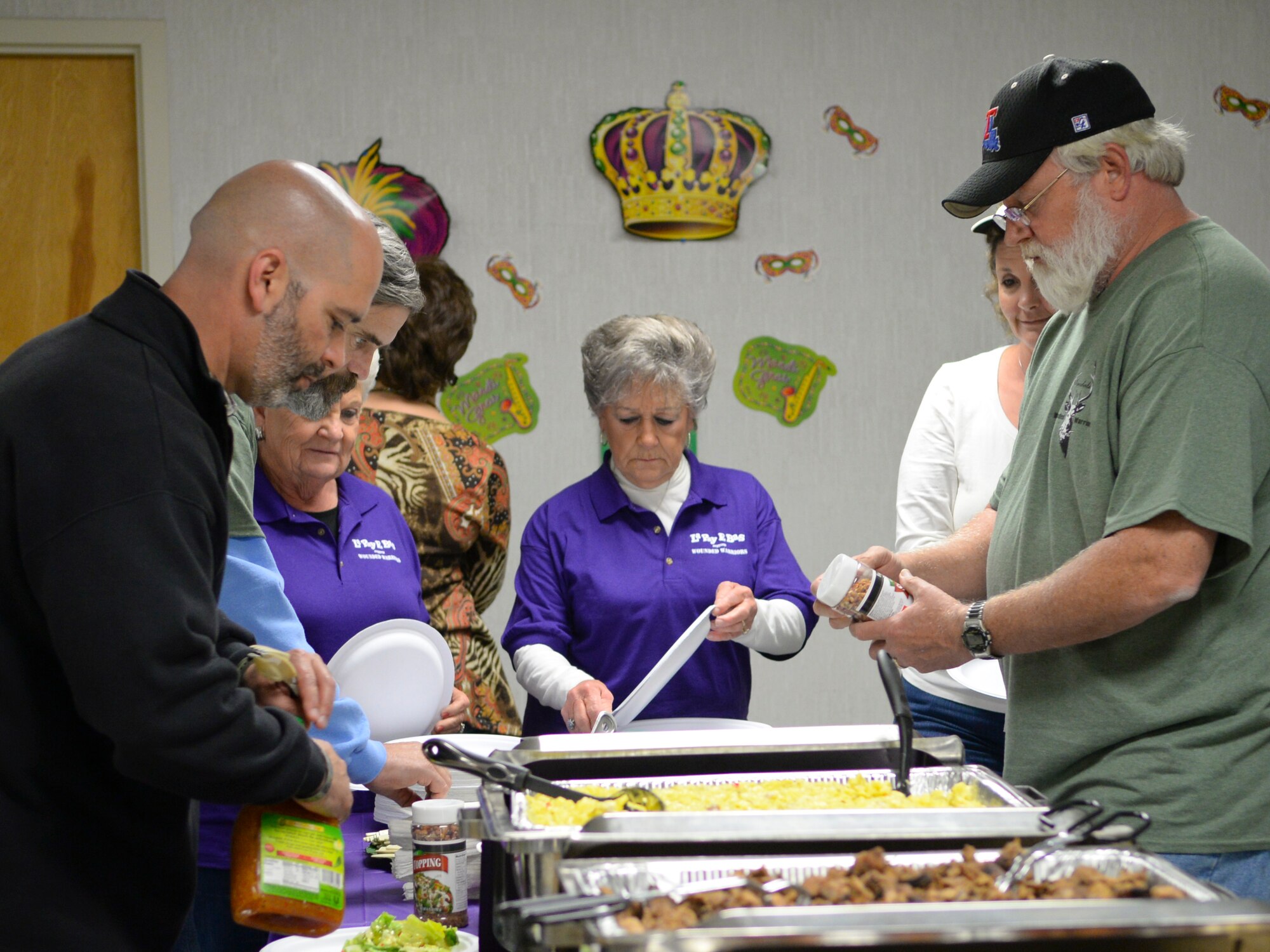 Team Barksdale wounded warriors, veterans and their families fill their plates at the Natural Resources facility during the Wounded Warrior Hunt on Barksdale Air Force Base, Nov. 7. During the social hour, barbecue, potato salad, dinner rolls and cake were served. (U.S. Air Force photo/Senior Airman Benjamin Raughton)