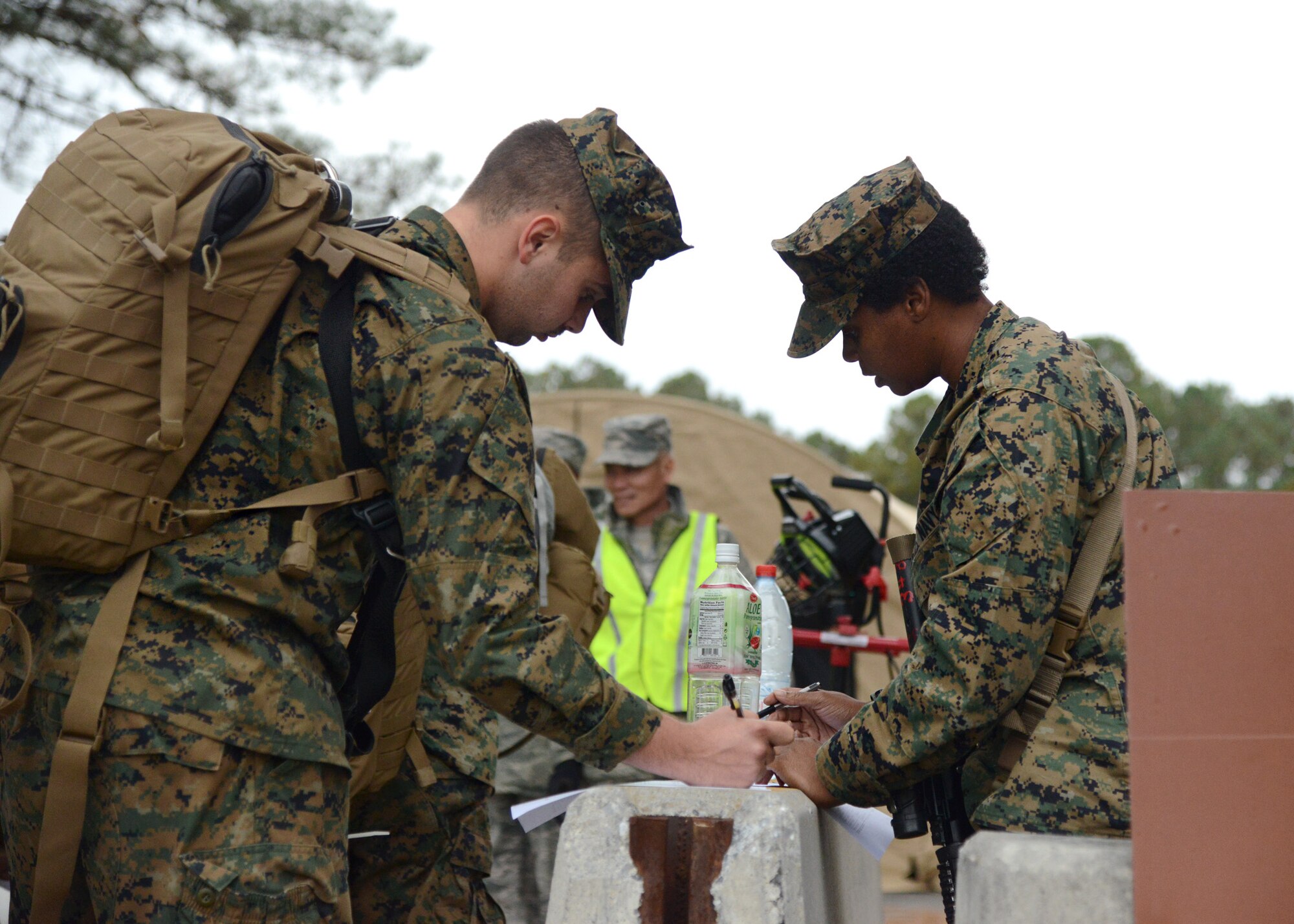 U.S. Marines complete paperwork upon arrival at Langley Transit Center at Langley Air Force Base, Va., Nov. 13, 2014. The Marines were among 90 Service members who will undergo a 21-day controlled monitoring period at the transit center following their return from fighting the spread of Ebola in West Africa as part of Operation United Assistance. (U.S. Air Force photo by Staff Sgt. Jason J. Brown/Released)