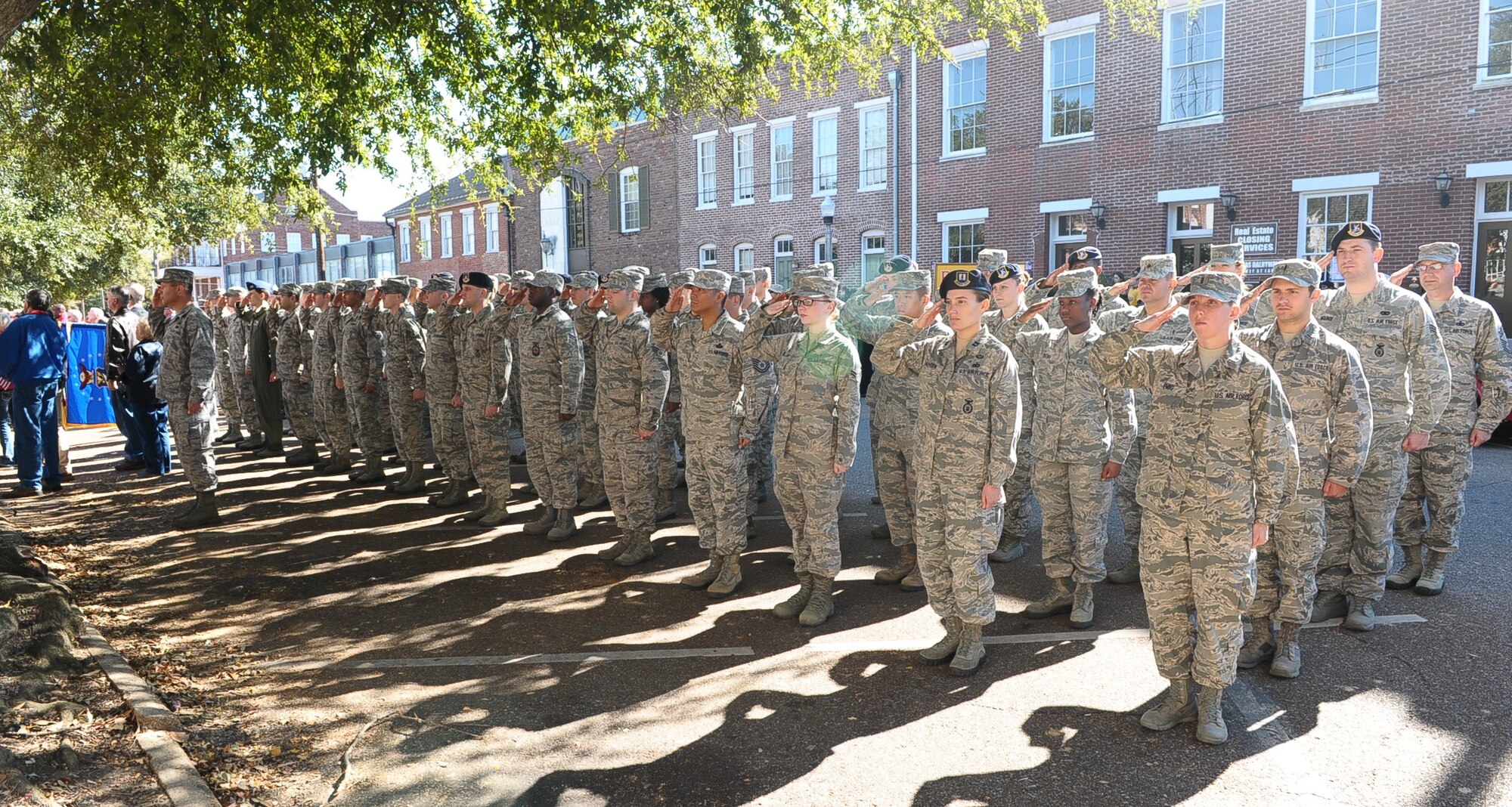 A formation of Airmen from Columbus Air Force Base salute the American flag while Taps plays Nov. 8 during the Veterans Day Ceremony at the Lowndes County Courthouse. The ceremony included a wreath-laying, a 21-dove salute, a speech from retired United States Marine Corps Maj. Gen. Thomas Moore, and ended with the playing of Taps. (U.S. Air Force photo/Airman Daniel Lile) 