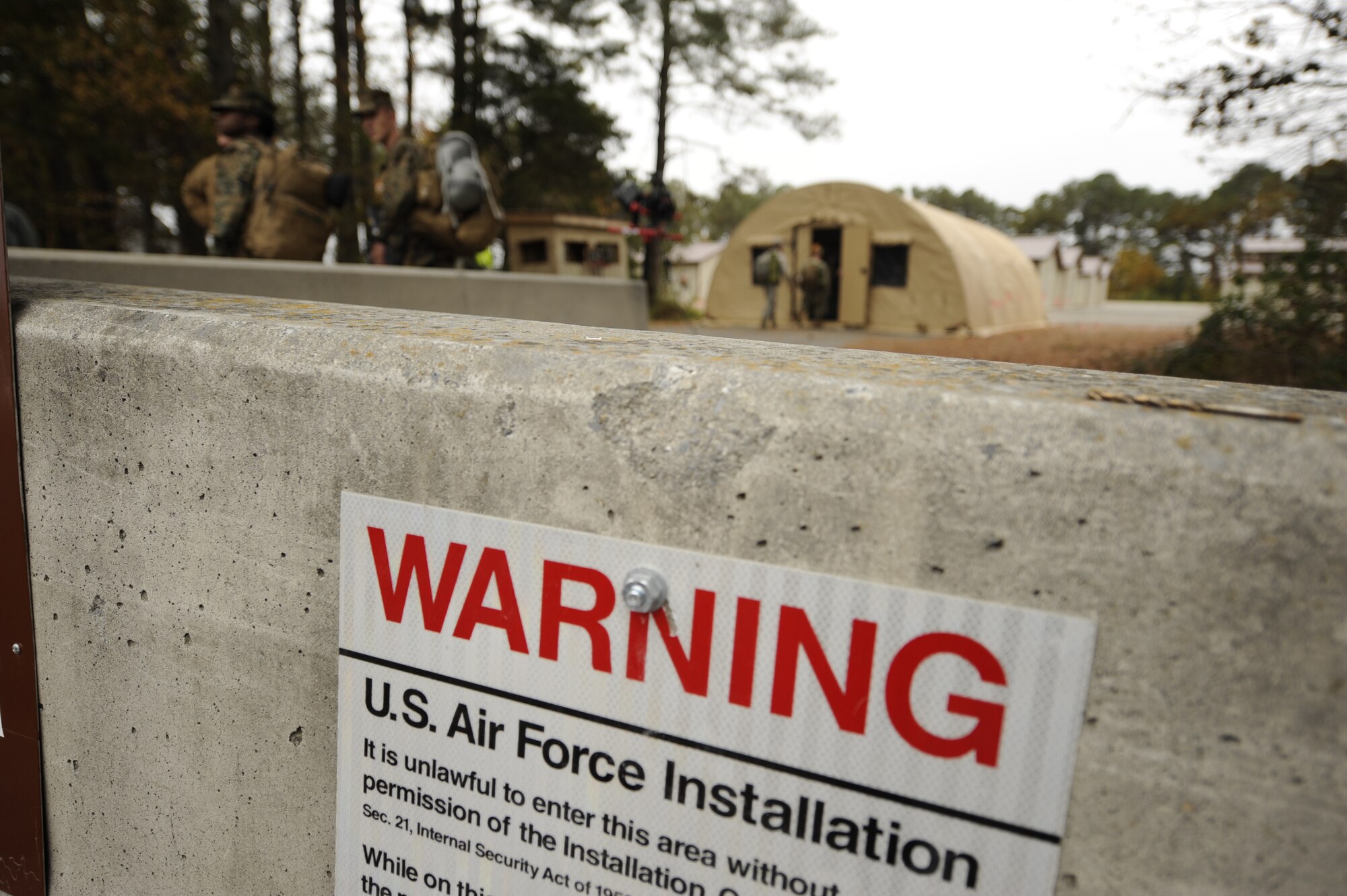 U.S. Service members enter the cordoned-off Joint Base Langley-Eustis’ Langley Transit Center, Va., Nov. 13, 2014. Ninety Service members, who returned from missions combating the Ebola Virus Disease in West Africa, are staying at the center for 21 days of controlled monitoring. The 21-day monitoring period was established by the Secretary of Defense, and during this period, Service members will be separated from their families and the general public. (U.S. Air Force photo by Staff Sgt. Natasha Stannard/Released)