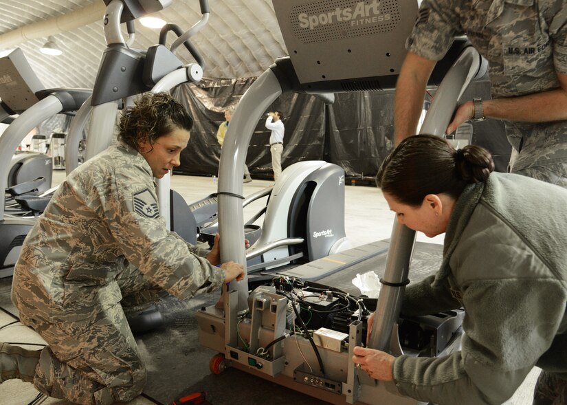 U.S. Air Force Master Sgt. April Donnelly, 633rd Force Support Squadron Shellbank Fitness Center manager (left), installs a treadmill in the Langley Transit Center fitness center at Langley Air Force Base, Va., Nov. 5, 2014. Donnelly, who is half Eastern Cherokee, takes pride in her Native American heritage, applying principles of family and community in caring for her family and her Airmen. (U.S. Air Force photo by Staff Sgt. Jason J. Brown/Released)