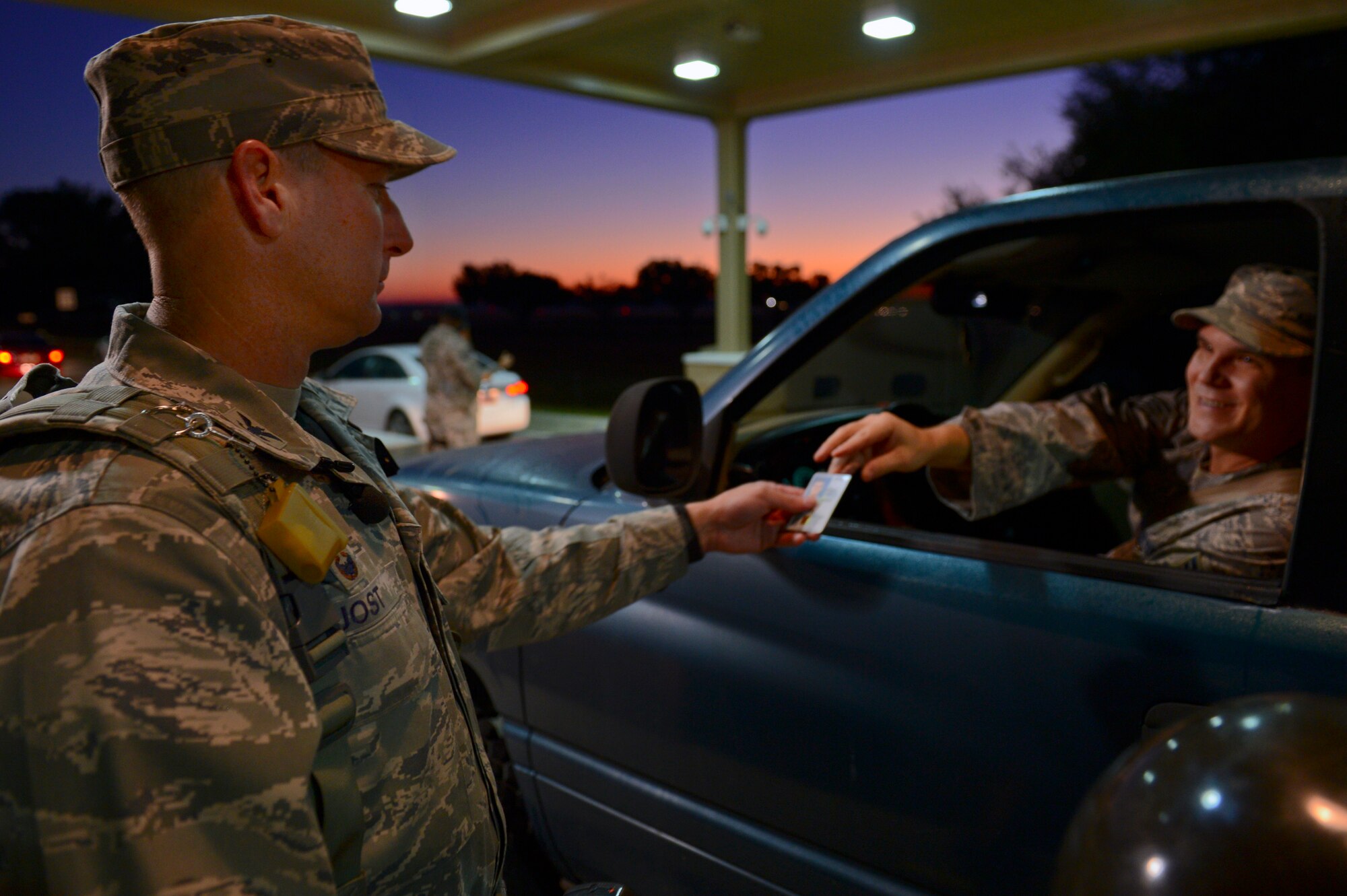 U.S. Air Force Col. Stephen Jost, 20th Fighter Wing commander, checks identification cards at the main gate at Shaw Air Force Base, S.C., Oct. 27, 2014. Jost checked ID cards during the morning traffic rush as part of his 12-hour “Behind the Scenes” job shadowing opportunity with the 20th Security Forces Squadron. (U.S. Air Force photo by Senior Airman Tabatha Zarrella/Released)