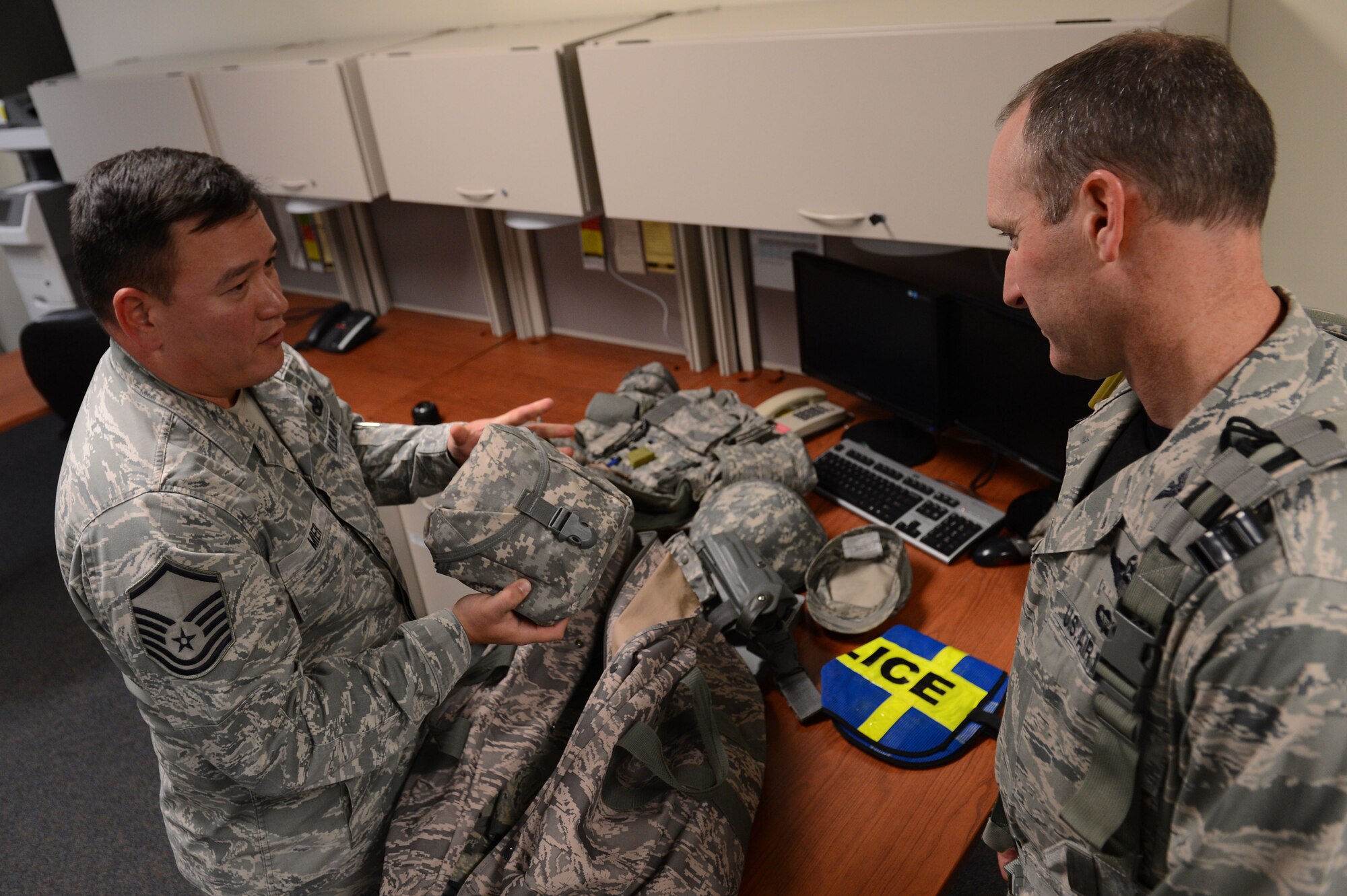 U.S. Air Force Master Sgt. Andrew Mier, 20th Security Forces Squadron, NCO in charge of training, shows Col. Stephen Jost, 20th Fighter Wing commander, the gear he will carry while on shift at Shaw Air Force Base, S.C., Oct. 24, 2014. Jost worked a 12-hour shift with security forces Airmen as part of a newly implemented “Behind the Scenes” job shadowing experience. (U.S. Air Force photo by Senior Airman Tabatha Zarrella/Released)