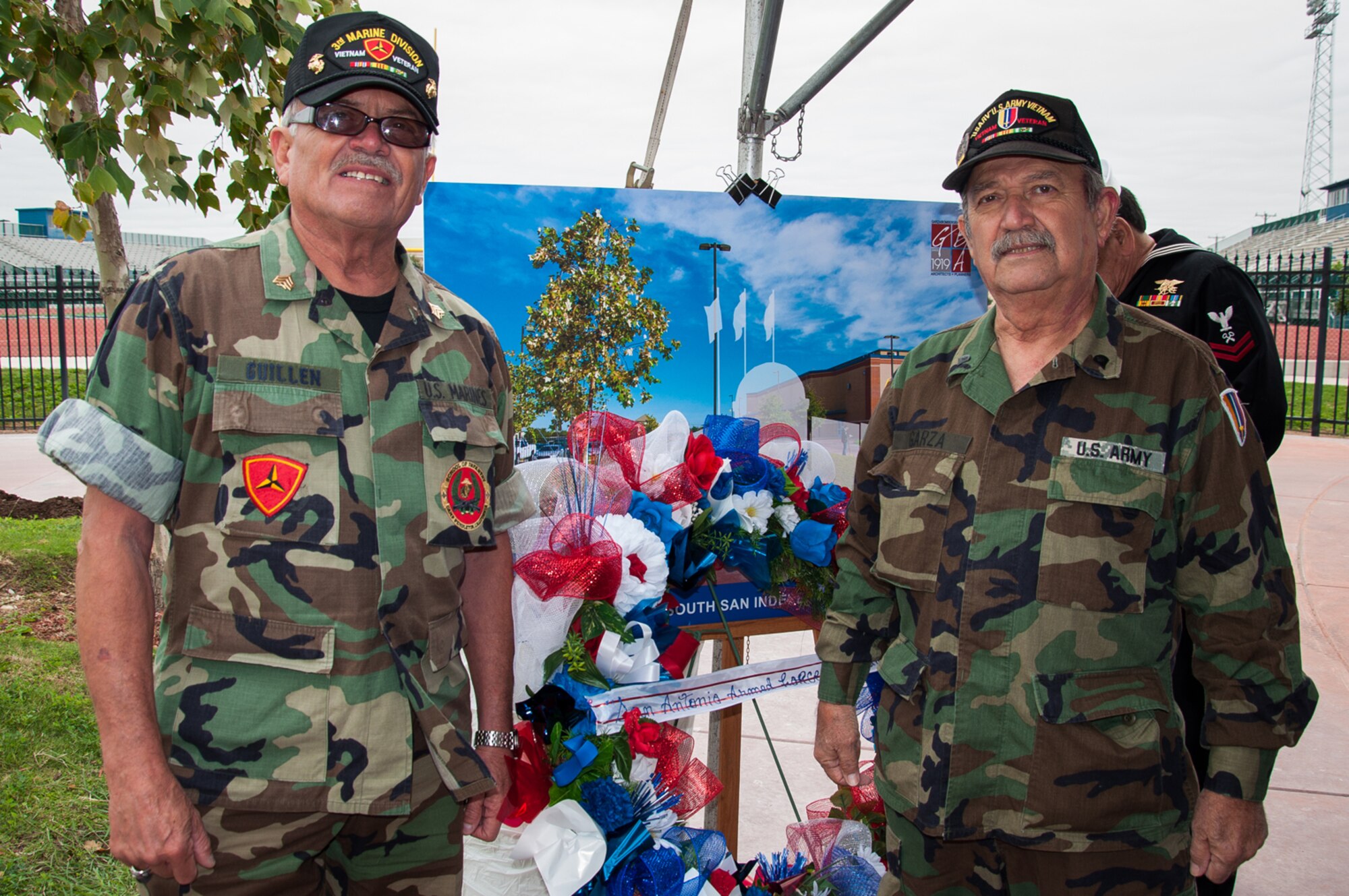 Manuel Guillen, a veteran who was one of the first Marines to land in Vietnam, and Humberto Garza, an Army veteran who served in the Vietnam War, stand next to the winning memorial design at a groundbreaking ceremony at South San Antonio High School, Nov. 11. The memorial is meant to commemorate native San Antonio veterans, from across the military services, who have lost their lives serving their country. (U.S. Air Force photo by 1st Lt. Jose R. Davis)