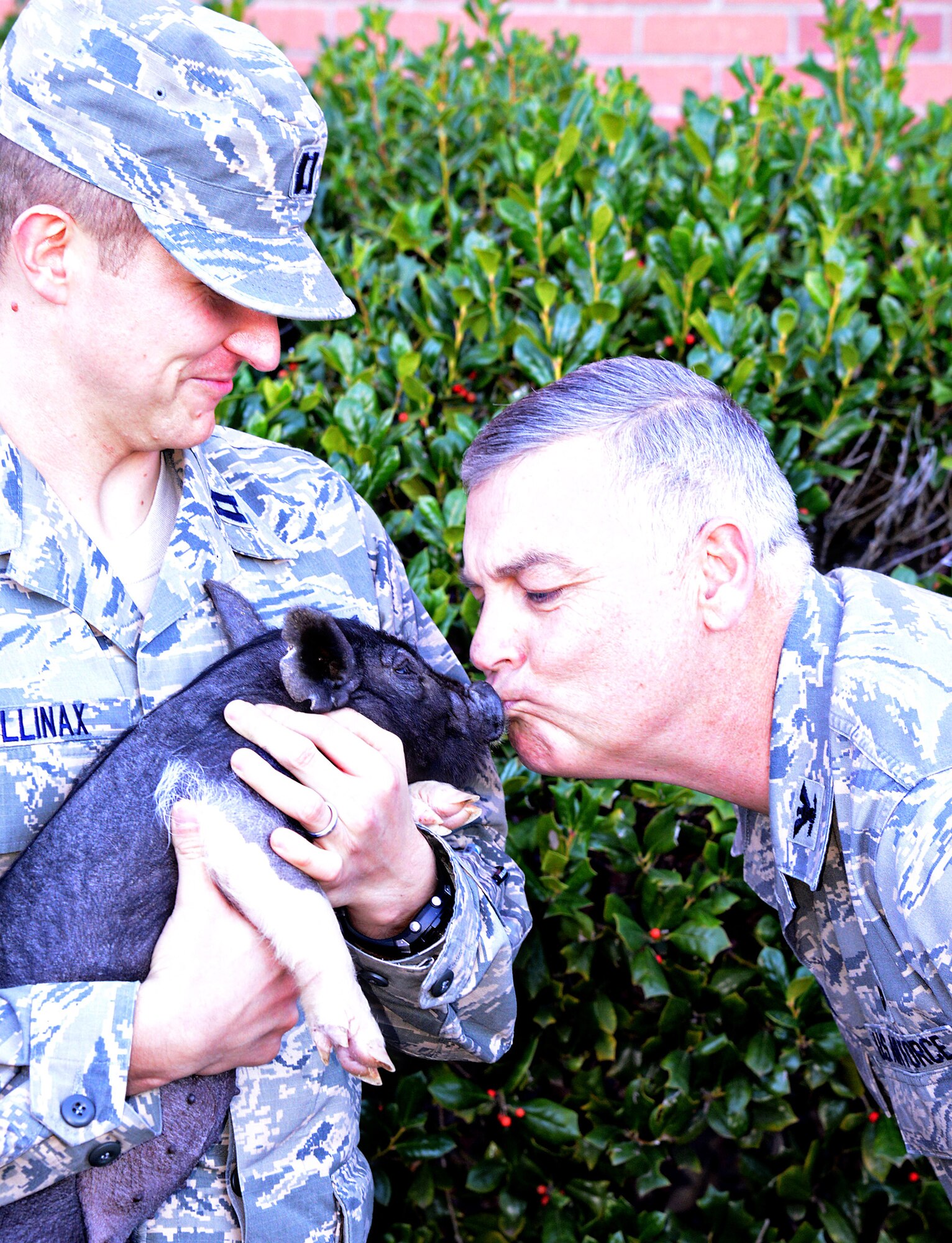 Col. Steve Petters, 76th Propulsion Maintenance Group commander, puckers up to a pig during the group’s Combined Federal Campaign “Kiss a Pig” fundraiser. Holding the pig is Capt. Robert Mullinax, Oklahoma City Air Logistics Complex executive officer. During the Nov. 7 event, which was held at both Bldgs. 3001 and 9001, people donated their dollars and voted for a PMXG senior leader to give the little pig a smooch. Other top vote-getters were Michael Barrett, 76th PMXG deputy director; Ed Arnold, 548th Propulsion Maintenance Squadron; Steve Fazio, 546th PMXS; Jeff Bradley, 76th PMXG; and Justin Hottle, 548th PMXS deputy director. The group raised approximately $2,133.98 for CFC. Saturday is the last day to donate to CFC. Pledge forms are available through organizations’ designated CFC key workers. Donors can sign up online through MyPay at https://mypay.dfas.mil/mypay.aspx. (Air Force photo by Kelly White)