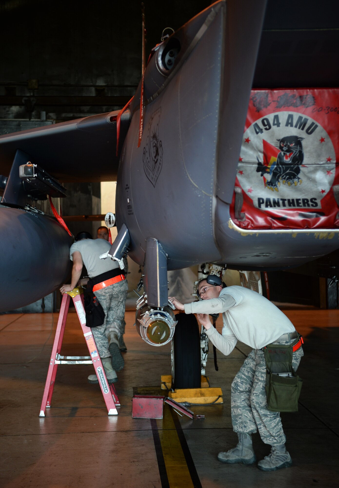 Tech. Sgt. Michael Delucy, right, and Airman 1st Class Ramsey Adair, 494th Aircraft Maintenance Unit load crew members, ensure munitions are loaded properly onto an F-15E Strike Eagle during a quarterly weapons load crew competition at Royal Air Force Lakenheath, England, Oct. 31, 2014. Each team of three is inspected on various tasks throughout the competition. (U.S. Air Force photo by Staff Sgt. Emerson Nuñez/Released)