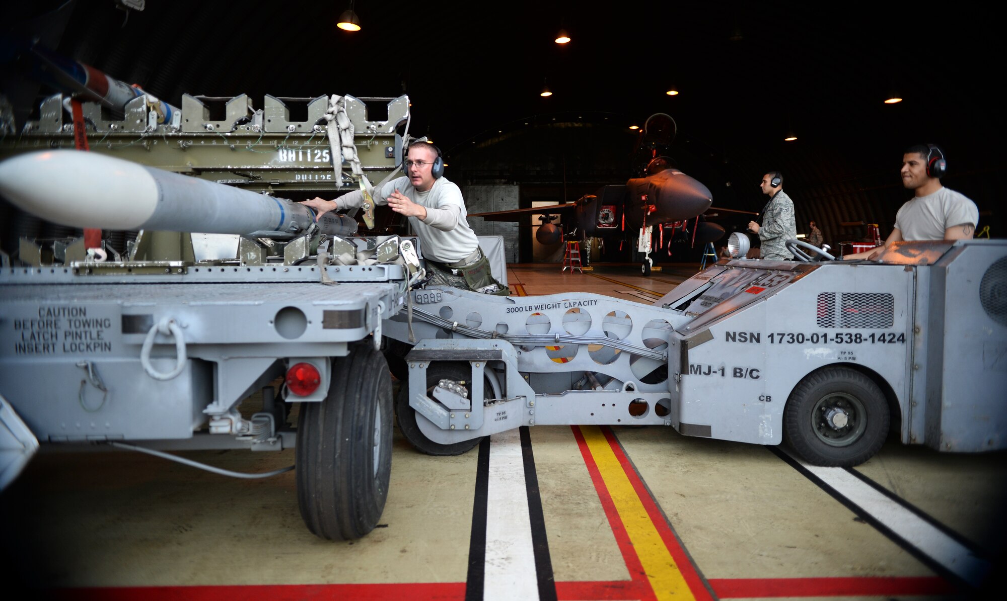 Tech. Sgt. Michael Delucy, left, and Airman 1st Class Dante Gibson, both 494th Aircraft Maintenance Unit load crew members, prepare to transport an Air Intercept Missile-9 during a quarterly weapons competition at Royal Air Force Lakenheath, England, Oct. 31, 2014. Evaluators inspected three teams loading munitions while displaying skills and capabilities in a timely manner. (U.S. Air Force photo by Staff Sgt. Emerson Nuñez/Released)