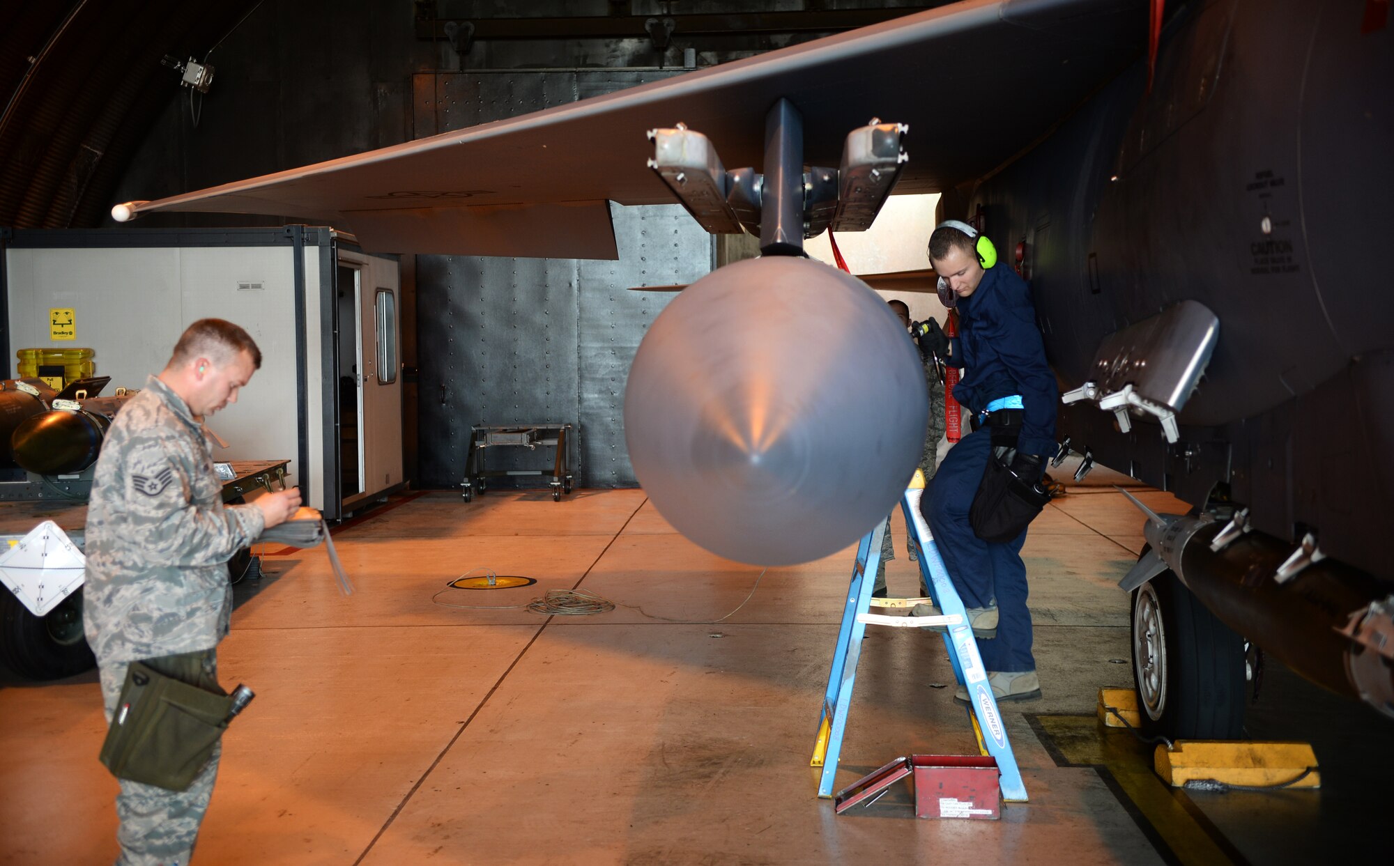 Senior Airman Matthew Kozanitis, right, 492nd Aircraft Maintenance Unit load crew member, reaches for a tool to prepare an F-15E Strike Eagle during a quarterly weapons competition at Royal Air Force Lakenheath, England, Oct. 31, 2014. Load crew competitions promote a safe, competitive environment where Airmen display their skills and the ability to apply what they’ve learned in training. (U.S. Air Force photo by Staff Sgt. Emerson Nuñez/Released) 