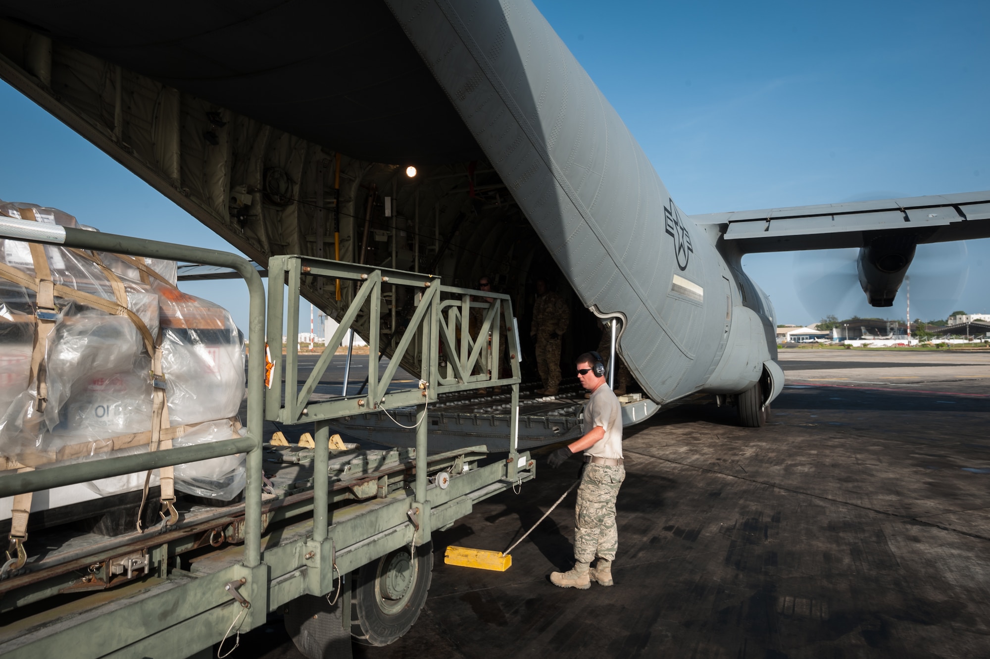 U.S. Air Force Tech. Sgt. Ryan McNary, an aerial porter from the Kentucky Air National Guard’s 123rd Contingency Response Group, directs humanitarian cargo onto a U.S. Air Force C-130J aircraft during an engines-running on-load at Léopold Sédar Senghor International Airport in Dakar, Senegal, Nov. 10, 2014. The aircraft and crew are deployed to Senegal from Dyess Air Force Base, Texas, as part of the 787th Air Expeditionary Squadron and will fly the cargo into Monrovia, Liberia, in support of Operation United Assistance, the U.S. Agency for International Development-led, whole-of-government effort to contain the Ebola virus outbreak in West Africa. (U.S. Air National Guard photo by Maj. Dale Greer)
