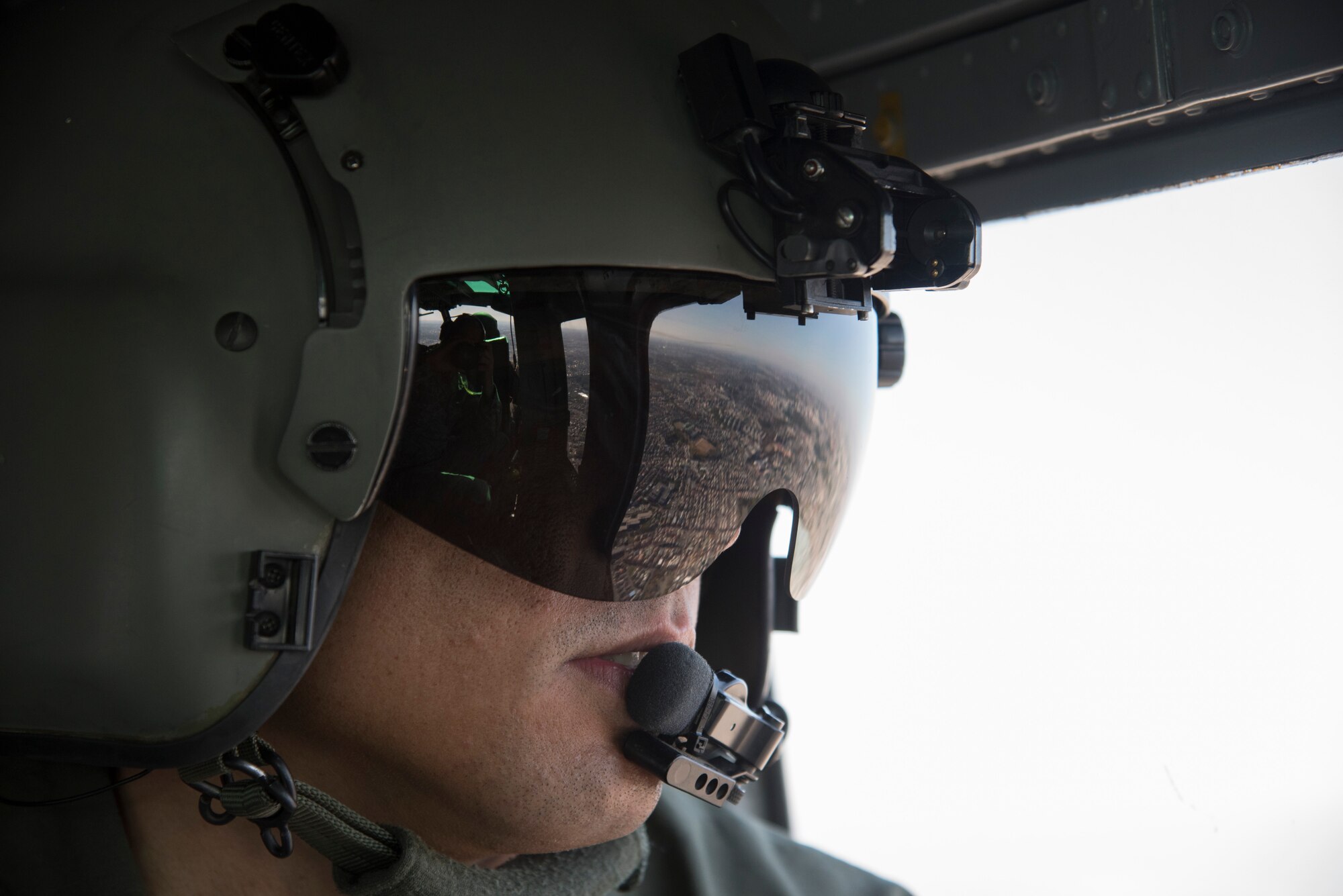 Staff Sgt. Michael Wright, 459th Airlift Squadron flight engineer, looks out the window of a UH-1N Huey on the way to Yokosuka Naval Station during aeromedical evacuation training for Exercise Keen Sword 2015 at Yokota Air Base, Japan, Nov. 13, 2014. While at Yokosuka, Wright briefed a group of Navy members on how to load and unload a litter patient. (U.S. Air Force photo by Senior Airman Michael Washburn/Released)