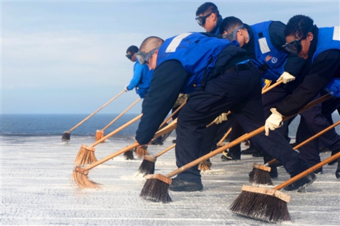 Sailors aboard the aircraft carrier USS John C. Stennis scrub the flight deck after testing a foam sprinkler system in Bremerton, Wash., Nov. 8, 2014.