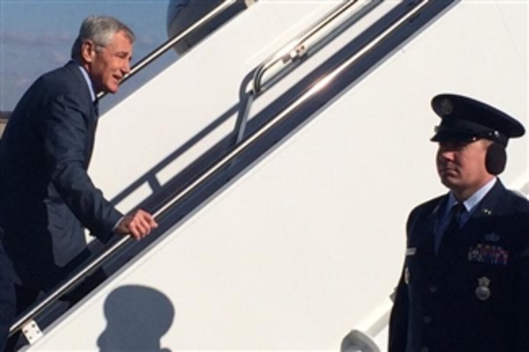 Defense Secretary Chuck Hagel waves before boarding a plane on Joint Base Andrews, Md., Nov. 14, 2014, to begin a five-day trip across the country to meet with the men and women of the Defense Department. The trip includes visits to Minot Air Force Base, N.D., Fort Irwin, Calif., Fort Campbell, Ky., and Camp LeJeune, N.C