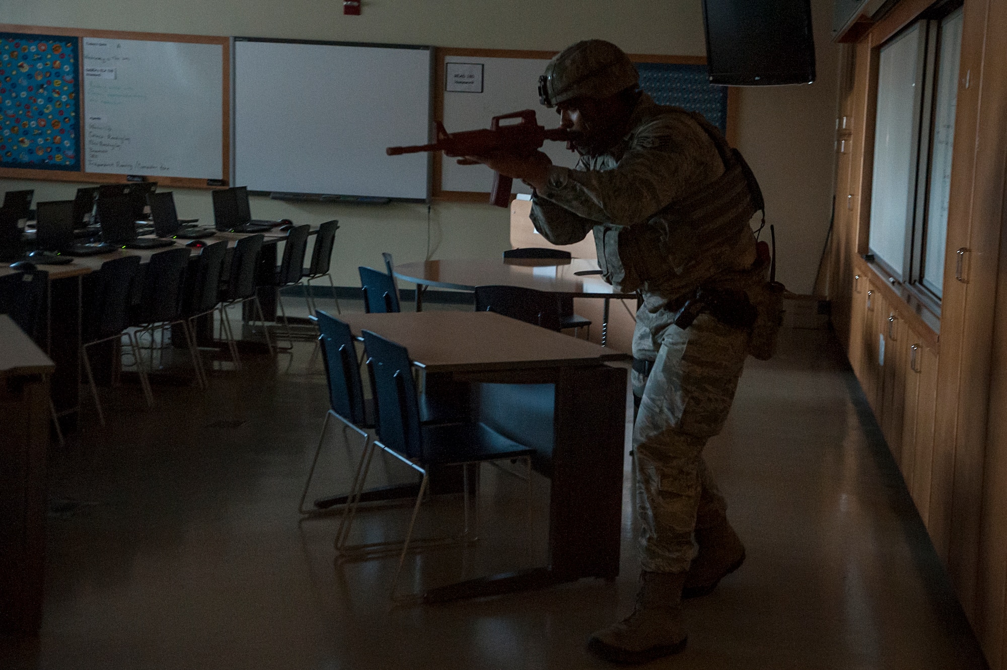 Staff Sgt. Carl Higgins, 51st Security Forces Squadron patrolman, clears a classroom for threats during an active shooter exercise at Osan Air Base, Republic of Korea, Nov. 13, 2014. All Osan Schools conducted a lockdown/shelter in place drills simultaneous to the active shooter exercise. (U.S. Air Force photo by Senior Airman Matthew Lancaster) 