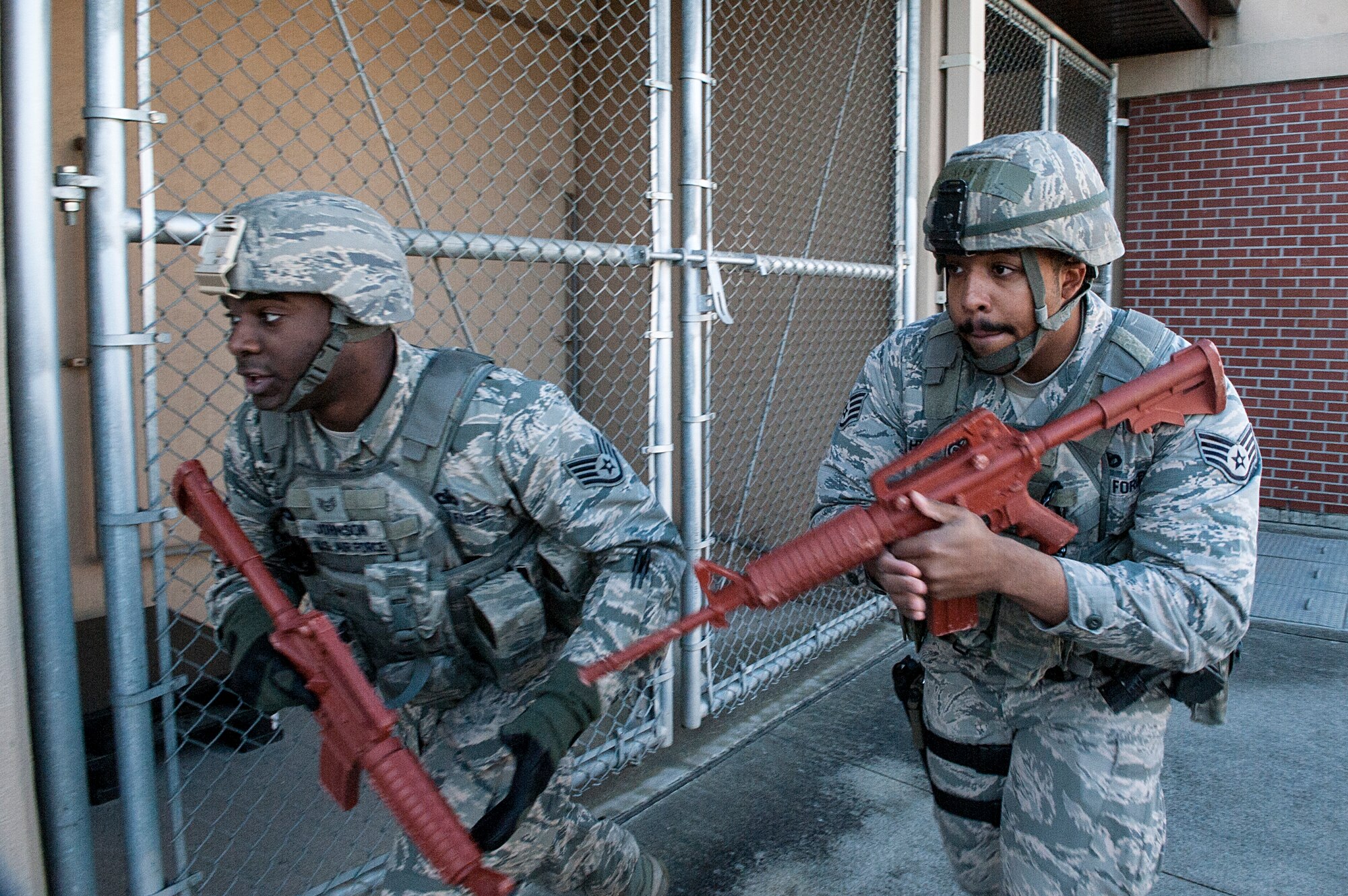 Staff Sgt. Pierre Johnson and Staff Sgt. Carl Higgins, 51st Security Forces Squadron patrolmen, look for a way in Osan Middle School during an active shooter exercise at Osan Air Base, Republic of Korea, Nov. 13, 2014. During the exercise, responders used rubber weapons to ensure no one is unintentionally injured. (U.S. Air Force photo by Senior Airman Matthew Lancaster)