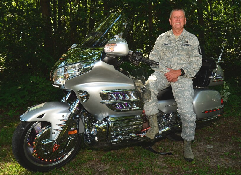 Senior Master Sgt. William Bassett, 932nd Airlift Wing, Superintendent of the Scott Command Post, takes a takes a minute to discuss the importance of motorcycle safety, while posing with his prized Goldwing.  About four years ago SMSgt Bassett was involved in an accident with his motorcycle, heading home from the base in the evening.  He came around a corner upon a dog, chasing a possum, and had to react quickly. He hit the brakes, but the bike started to slide, and he went over the handle bars. He was pinned to the ground, with his bike on top of him. When he came to, he was looking at the yellow lines in the middle of the road. "It was dark, and the first thing to come into my mind besides being crushed was, someone is going to come around the corner and hit me, I literally decided that I wasn't going to die that night," Bassett said.  The bike weighed eight hundred pounds, he swore he had five hundred of it on his chest, but he pushed his knees into the hot pipes, and pushed the bike up off of him with his back. "I guess that is what adrenaline will do," Bassett added "finally he heard someone come down the hill saying they had called 911."  "When I saw my helmet the next day, it was split entirely open, so what would that have done to my head" "No matter how short the distance, always wear a helmet", said Bassett. 
Most accidents are going to happen in a parking lot, or within a few miles of your house. When riding a motorcycle you have to be so much more aware of your surroundings than when riding in a car. The first thing I used to ask students when I was teaching motorcycle safety was, "do you remember every stop light you stopped at, and what was playing on the radio, or even what you were thinking about when you were coming to work" People are always distracted by something when they are driving; you have to watch out for those people. "I try to pick the person I want to get in front of, based on my observations" said Bassett. When riding you always want t