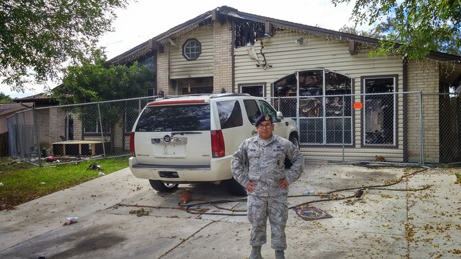 Senior Airman Christopher Taylor stands outside the remains of the burnt building in San Antonio, Texas. Taylor saved a disabled man from a fire, Nov. 3, 2014. The man was admitted to the San Antonio Military Medical Complex where he remains for treatment due to minor burns on the left side of his body and severe smoke inhalation. Taylor currently serves in the 802nd Security Forces Squadron pass and processing section. (U.S. Air Force photo/Senior Airman Lynsie Nichols)