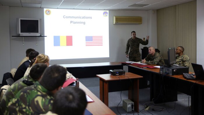 1st Lt. Julian D’orsaneo (rear center) begins his class on in-depth communications planning. Communications Marines from Black Sea Rotational Force held a two-day military-to-military training exercise Nov. 12-13 in Constanta, Romania with members of the Romanian Armed Forces to discuss communication tactics, techniques, and procedures.